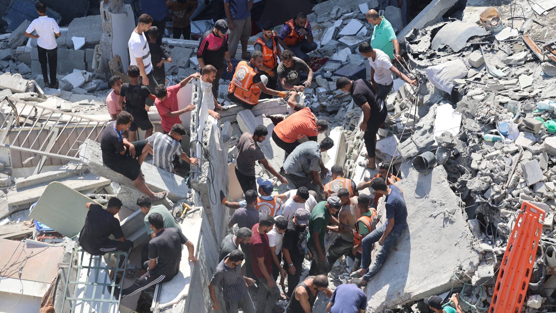 فلسطينيون يبحثون عن ناجين وسط أنقاض مبنى انهار بعد قصف الاحتلال في حي الشيخ رضوان بمدينة غزة