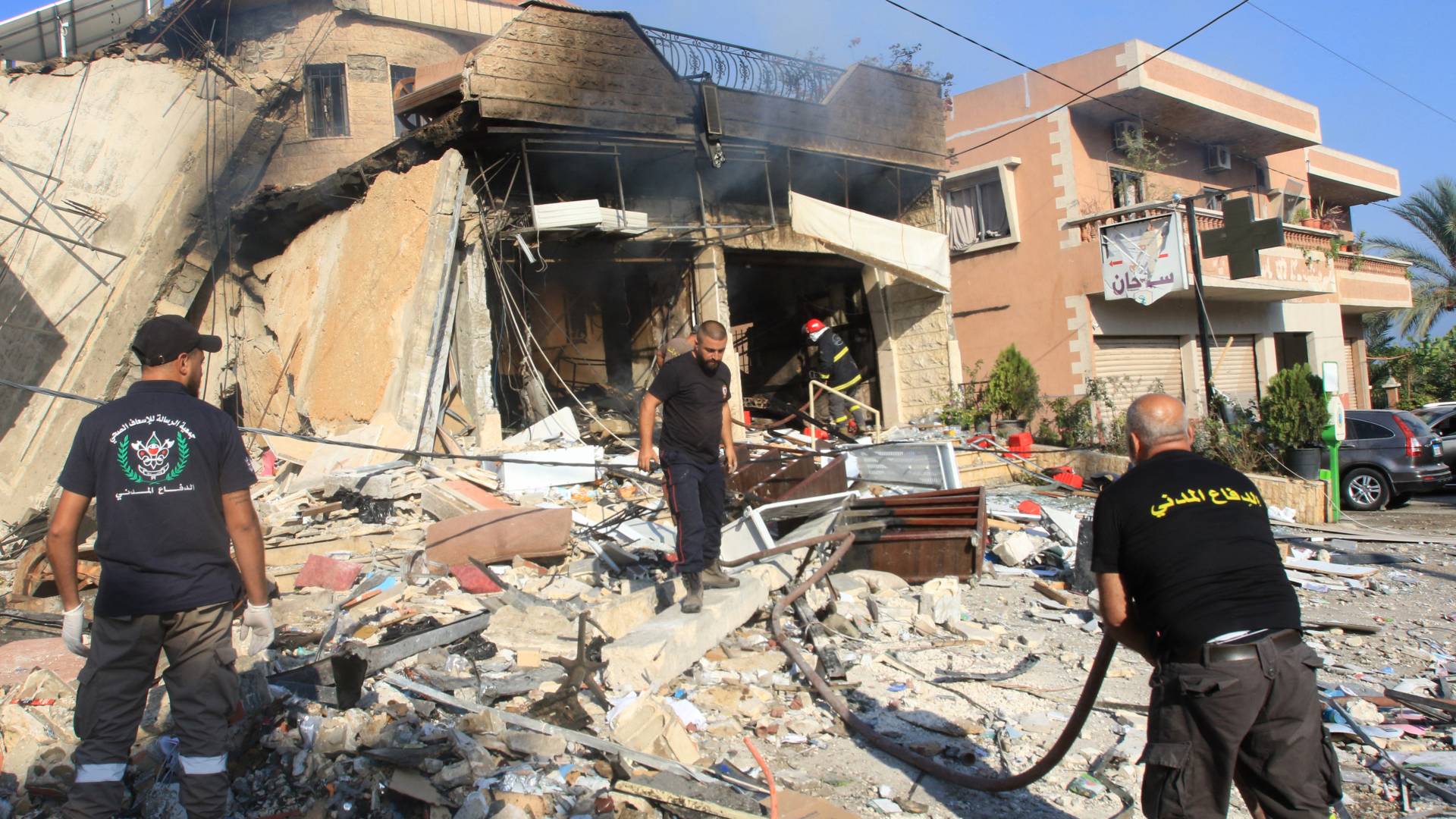 رجال الإنقاذ يتفقدون الحطام في موقع غارة للاحتلال ليلا على صيدلية في قرية العقبية بجنوب لبنان