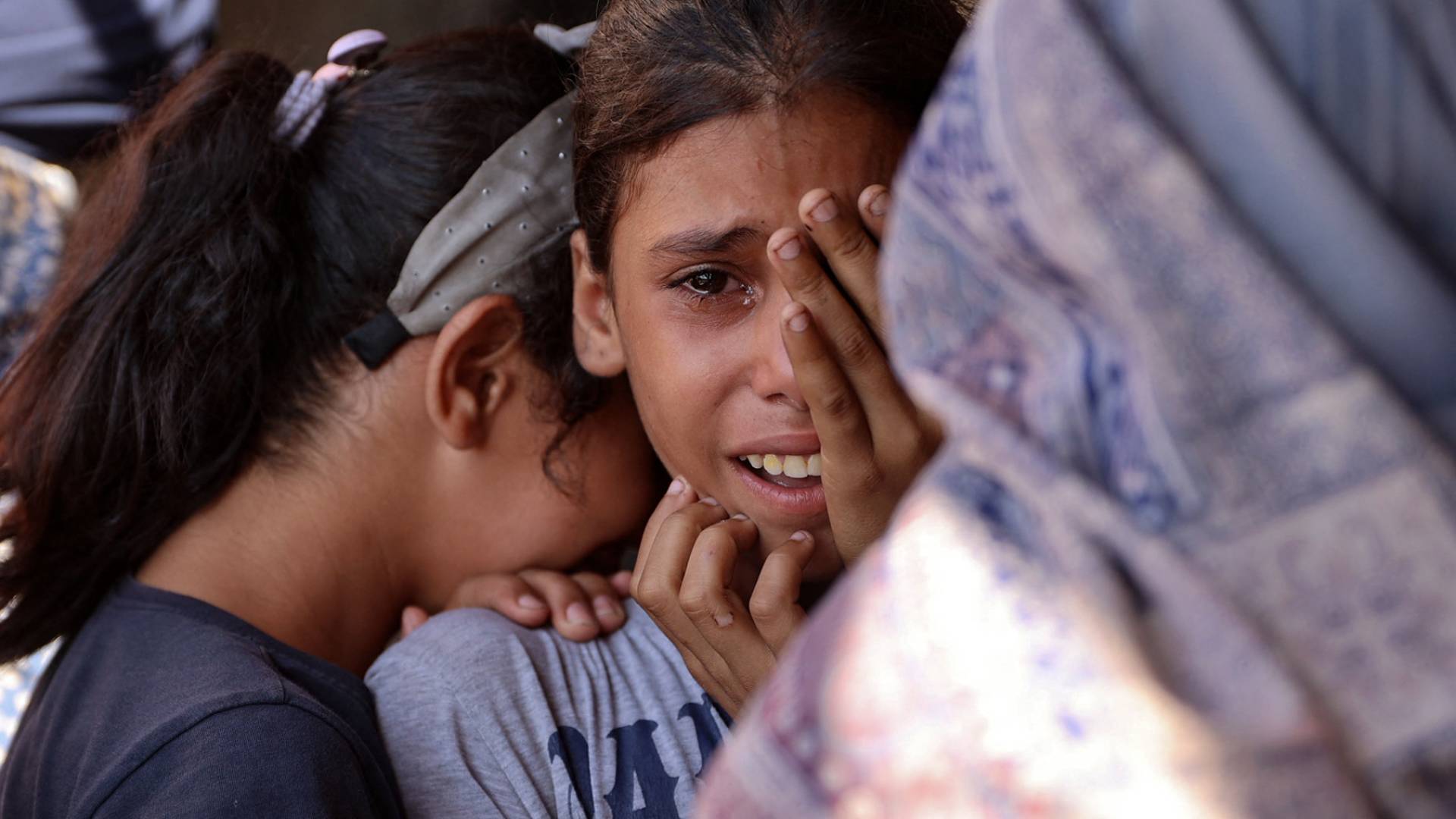 فتاتان فلسطينيتان تبكيان ألما في غزة