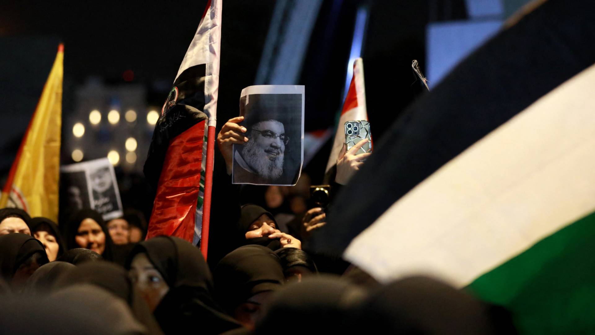 سيدة ترفع صورة حسن نصر الله