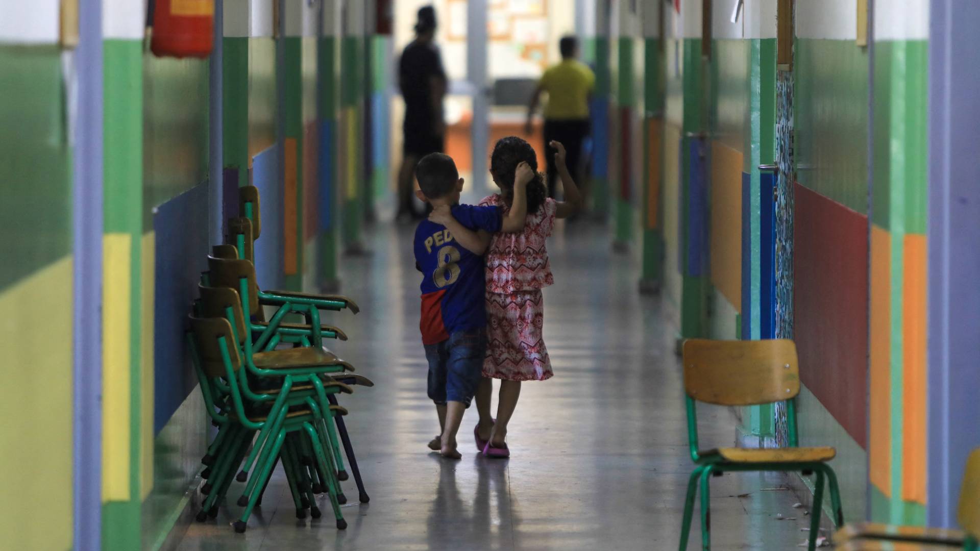 أطفال يسيرون في ممر مدرسة تؤوي عائلات نازحة من جنوب لبنان