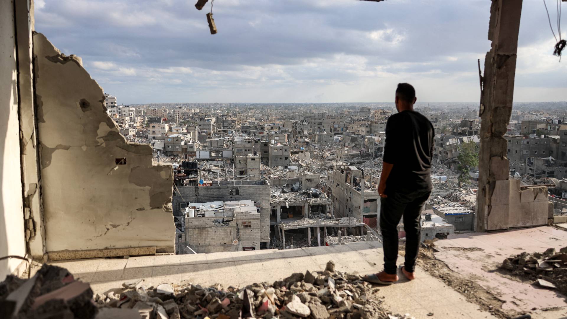 فلسطيني يناظر دمار أحياء سكنية بغزة