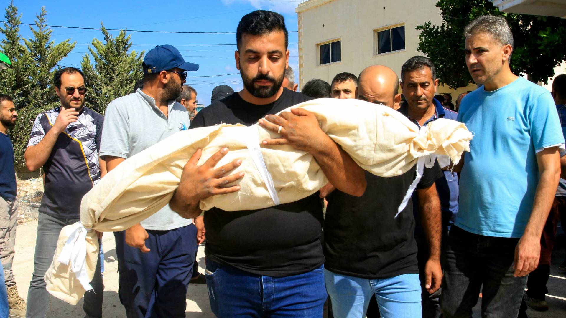 لبناني يحمل جثمان طفله