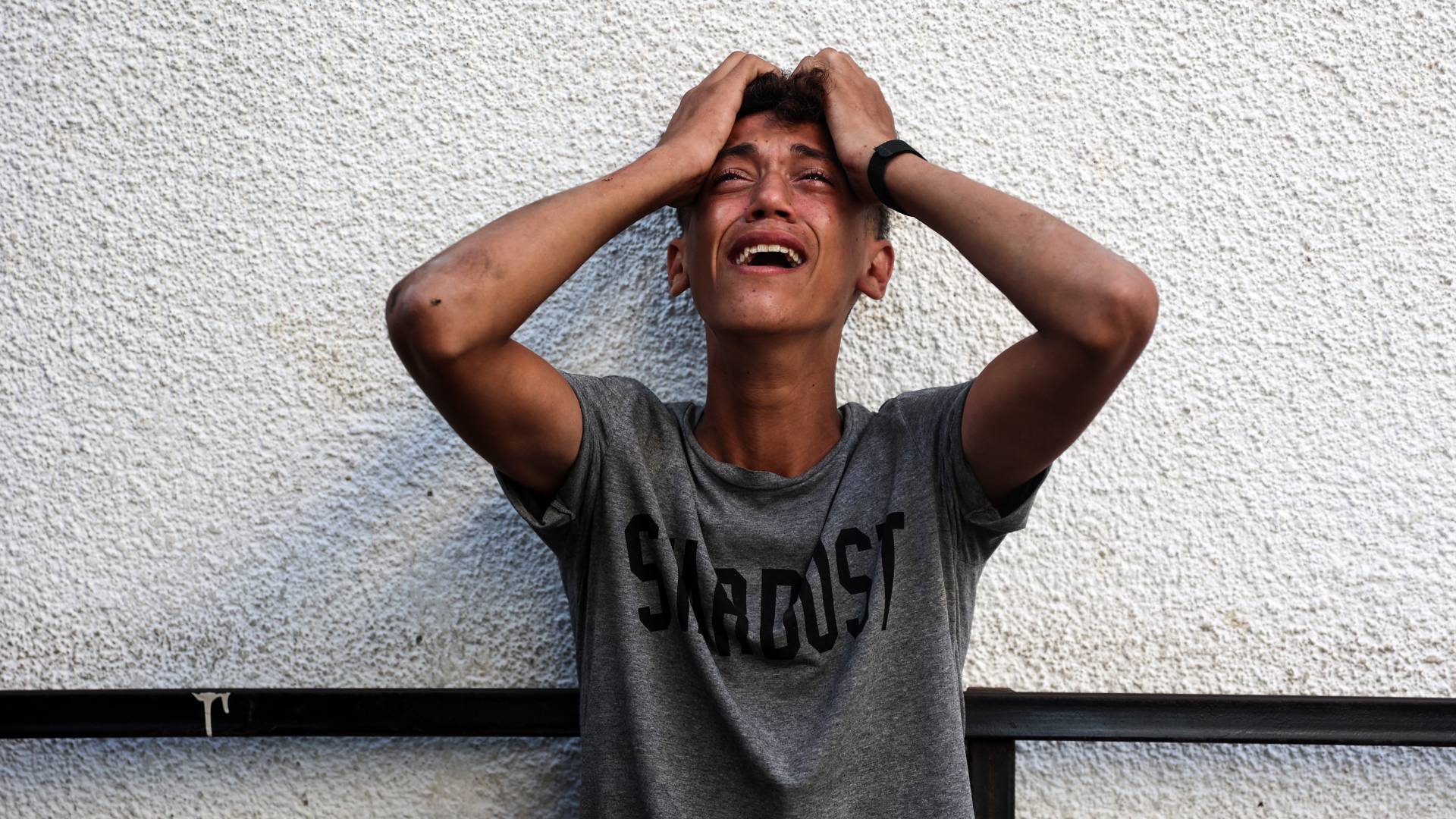 شاب فلسطيني يبكي مع رؤية جثث أقاربه الذين استشهدوا في غارة جوية إسرائيلية ليلا في مخيم جباليا