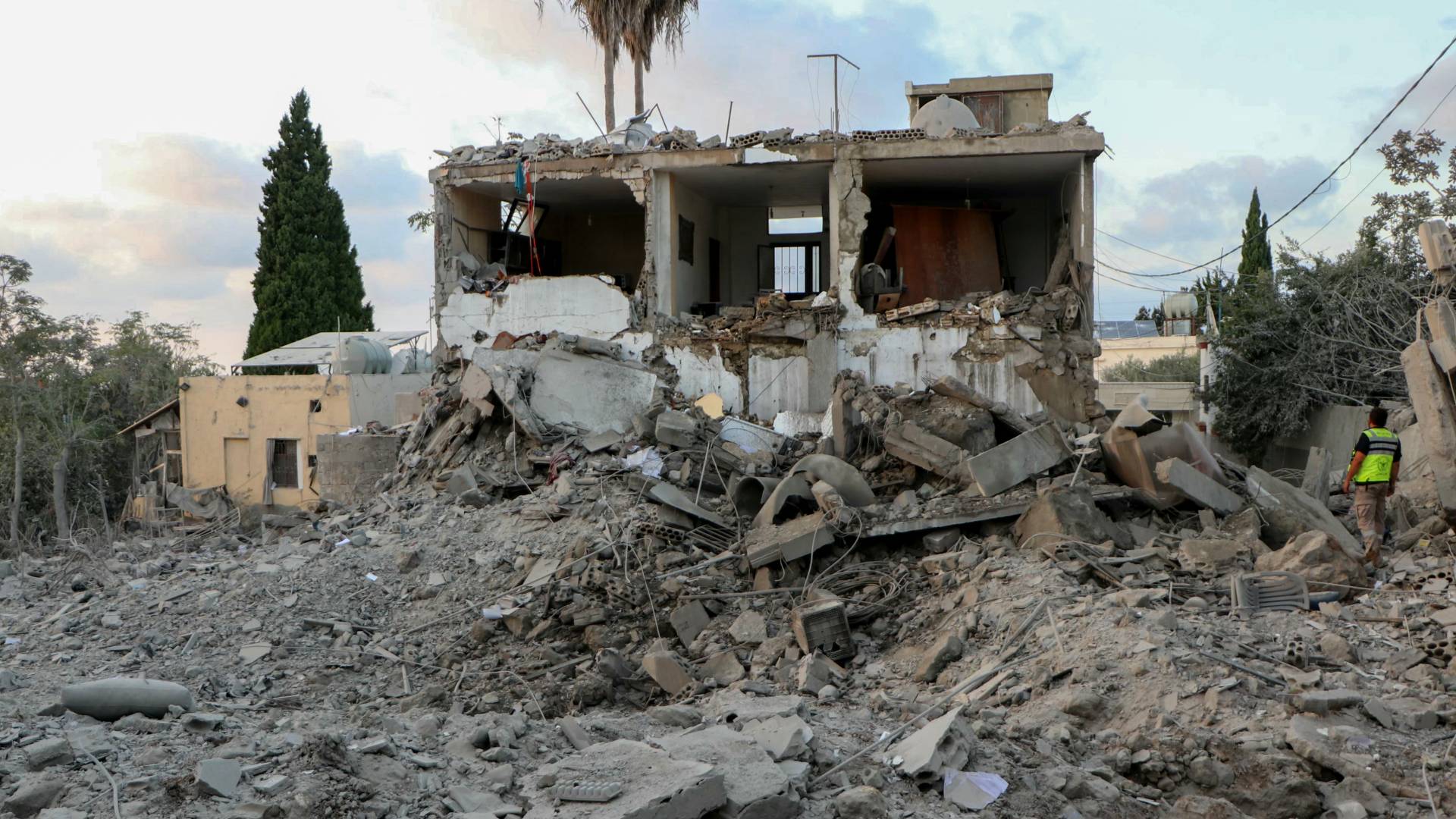 منقذ يقف على أنقاض مبنى دمر في غارة جوية للاحتلال استهدفت قرية الحنوية بجنوب لبنان