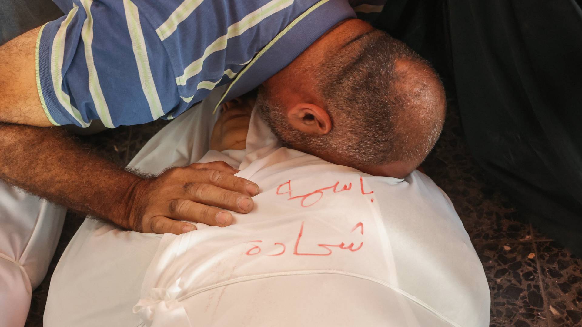 فلسطيني يودع سيدة من أفراد عائلته في غزة