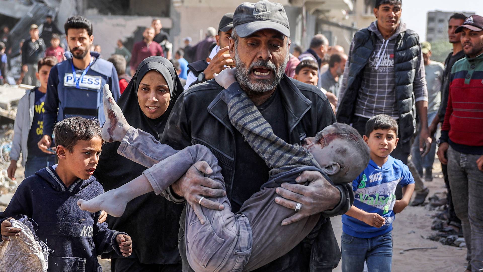 فلسطيني يحمل ابنه لمحاولة إنقاذه في قطاع غزة "أ ف ب"