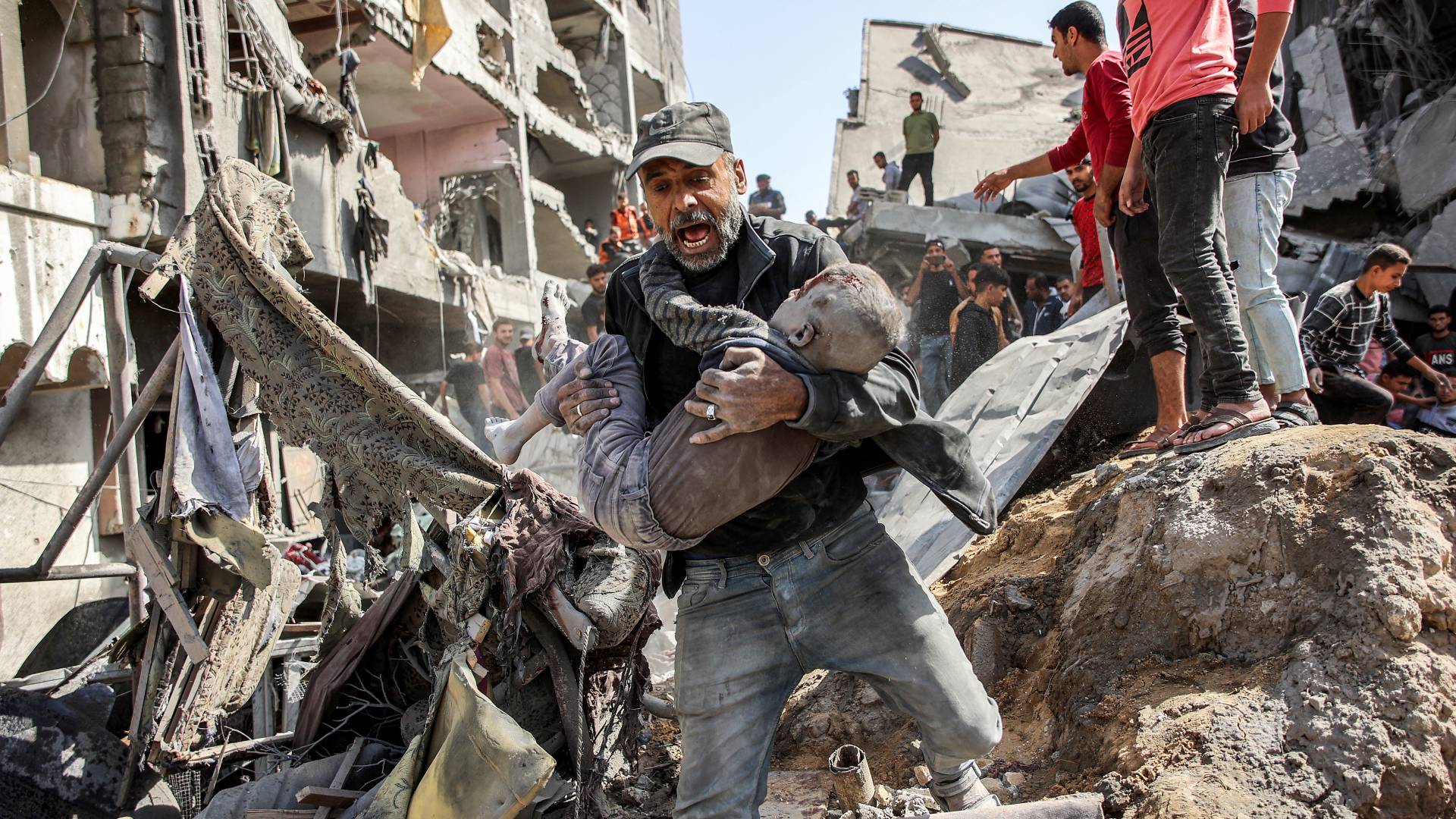 فلسطيني يحاول إنقاذ ابنه من الاستهدافات