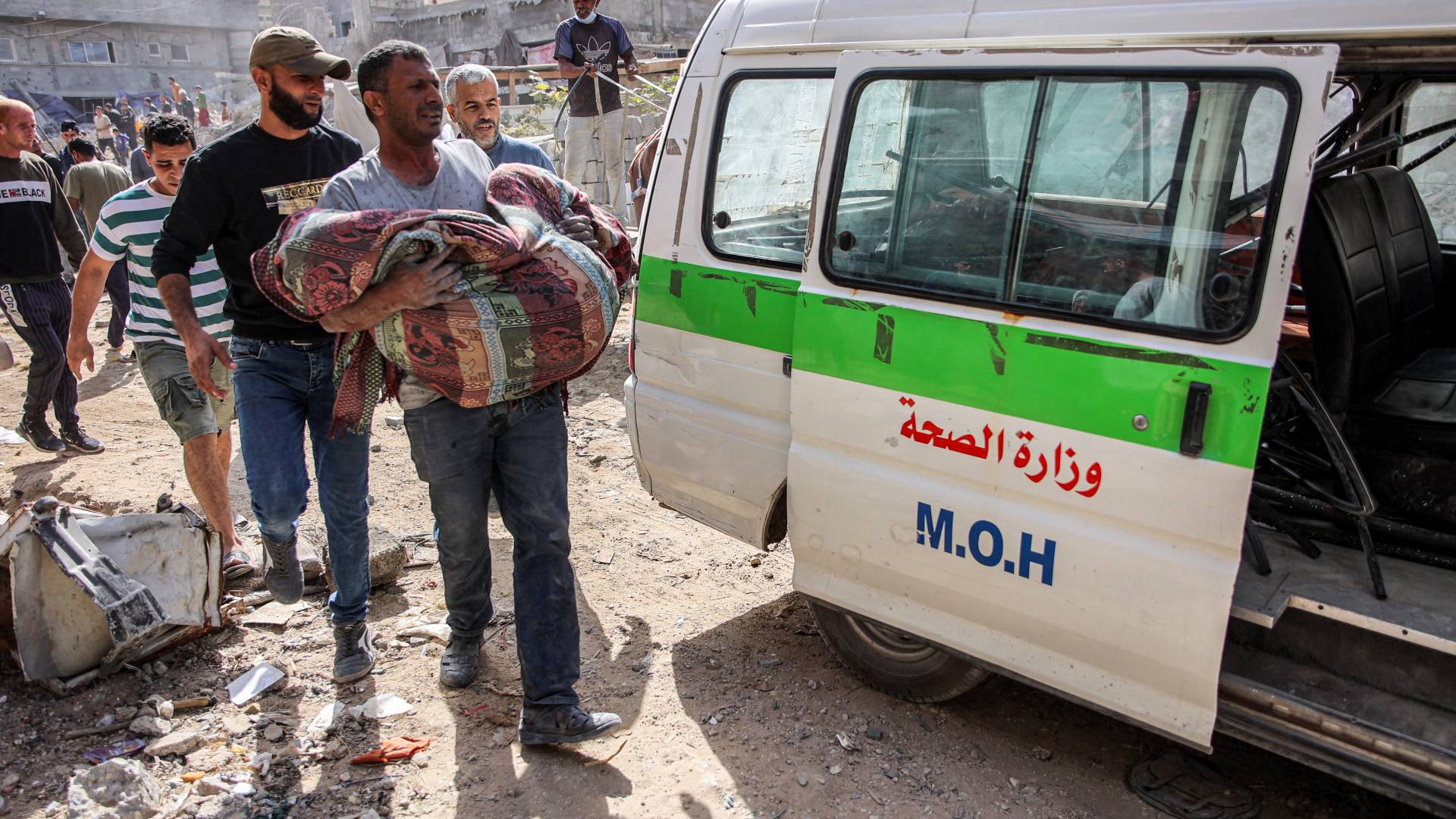 فلسطيني يحمل جثمان شهيد في غزة