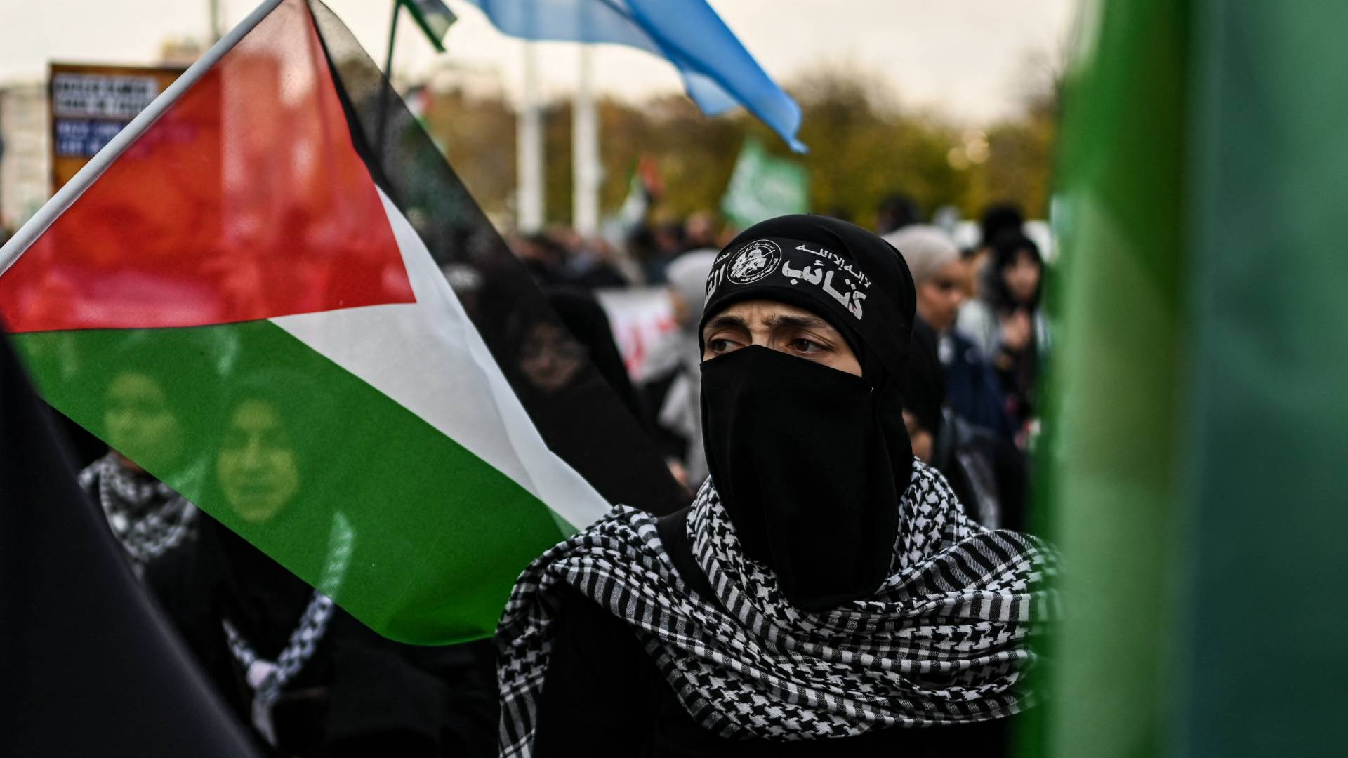 شخص ملثم وخلفه علم فلسطين خلال تظاهرة تضامنية في ألمانيا "أ ف ب" "تعبيرية"