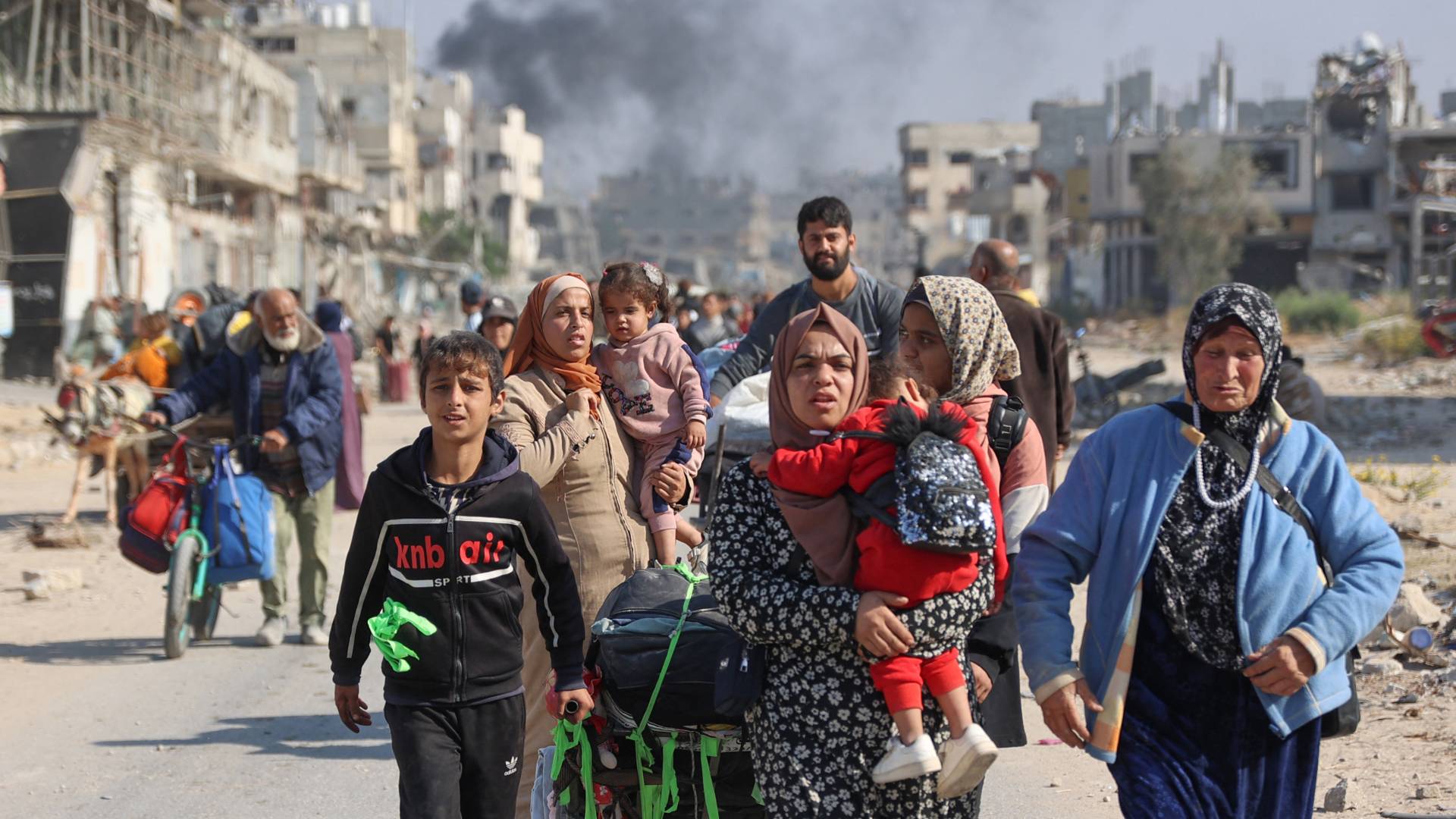 يعبر الفلسطينيون النازحون من الملاجئ في بيت حانون طريق صلاح الدين الرئيسي إلى جباليا في شمال قطاع غزة