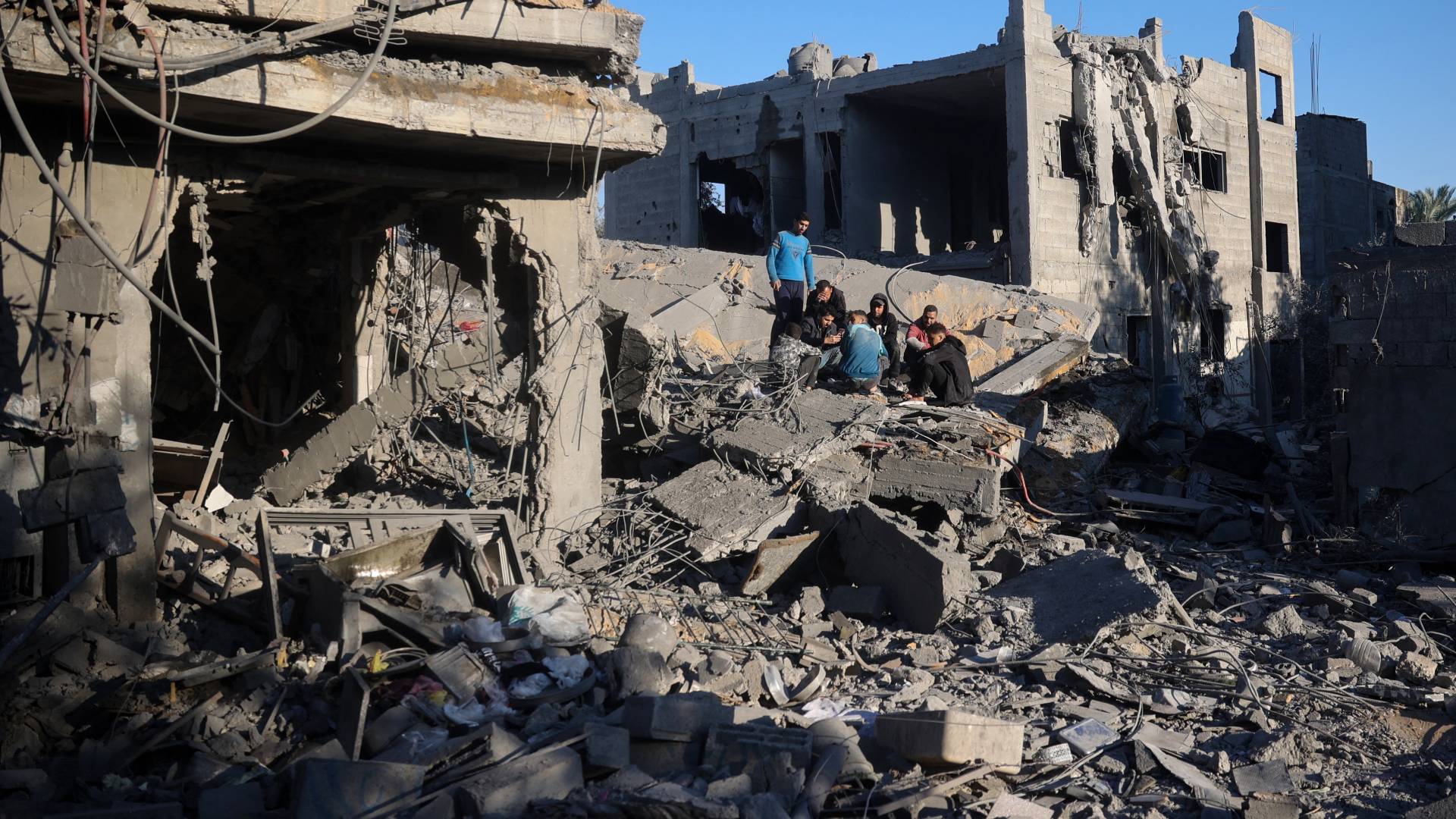 فلسطينيون يتجمعون فوق أنقاض منزل دمرته غارة للاحتلال في مخيم النصيرات وسط القطاع