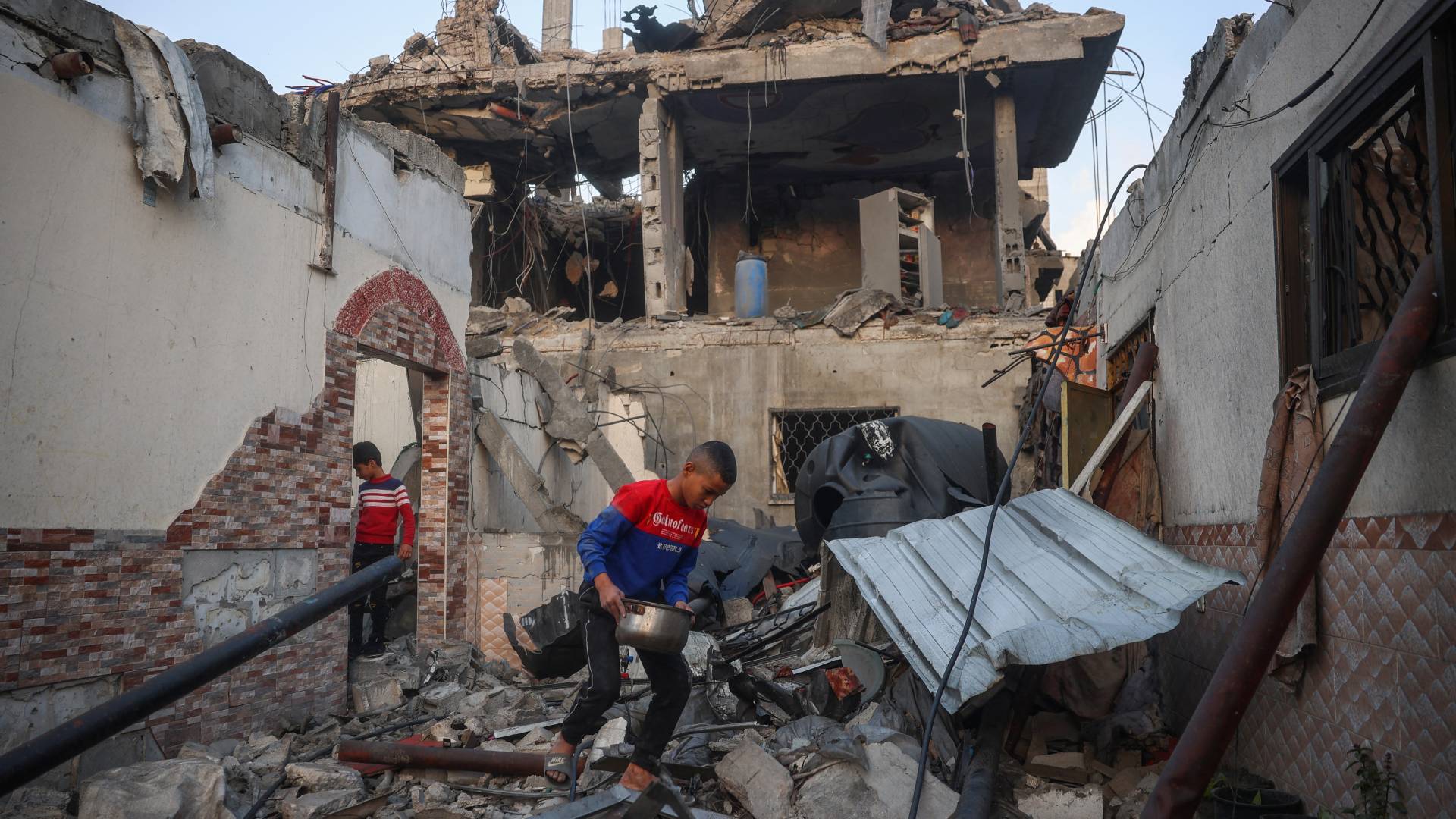 فلسطينيون ينقذون أشياء من تحت أنقاض منزل دمر في غارة للاحتلال في مخيم البريج في وسط غزة