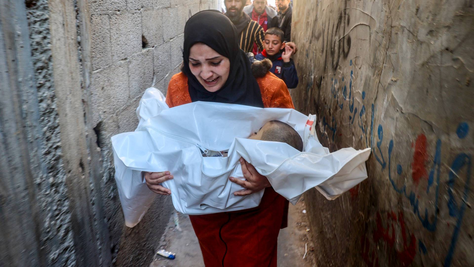 فلسطينية تحمل طفلها الشهيد