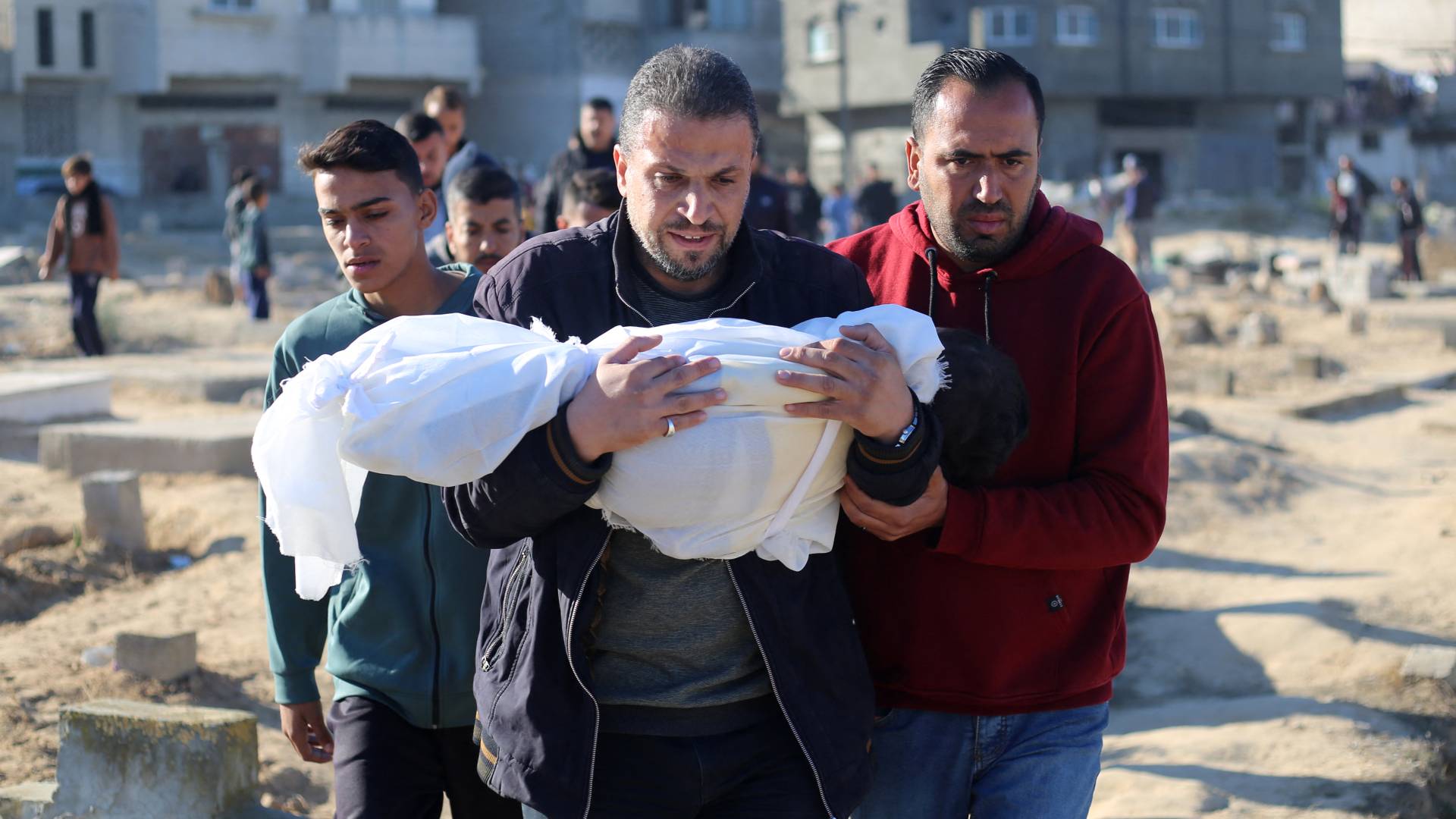 فلسطينية يحمل طفله الشهيد في قطاع غزة "أ ف ب"