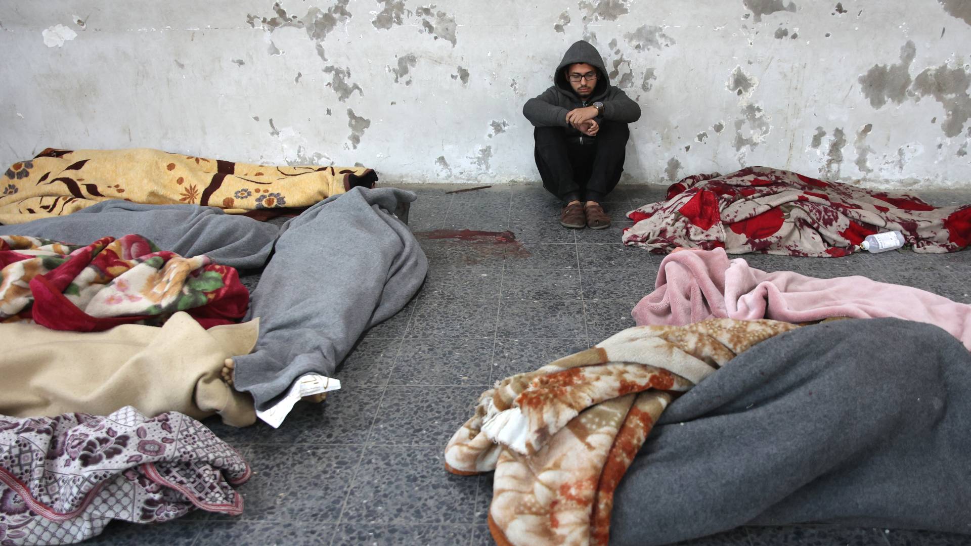 شاب فلسطيني يجلس بين جثامين الشهداء في غزة