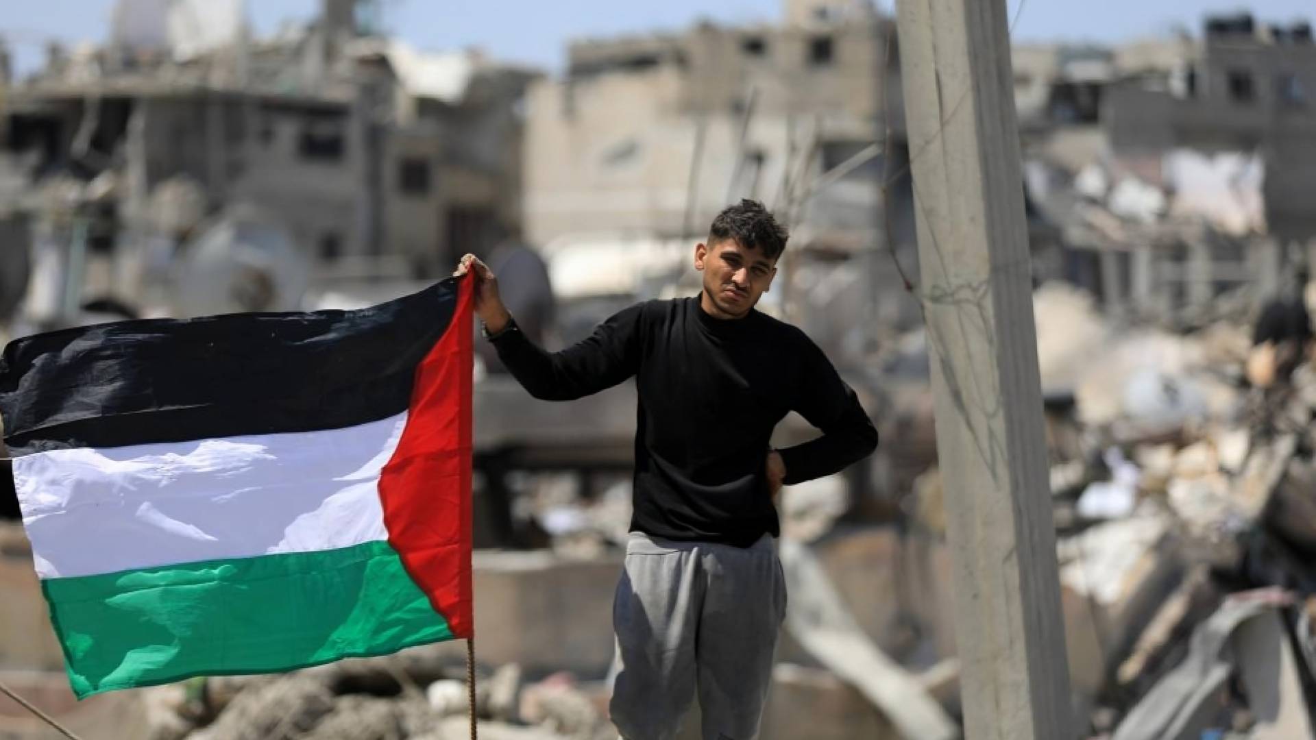 فلسطيني يتمسك بعلم بلاده في قطاع غزة