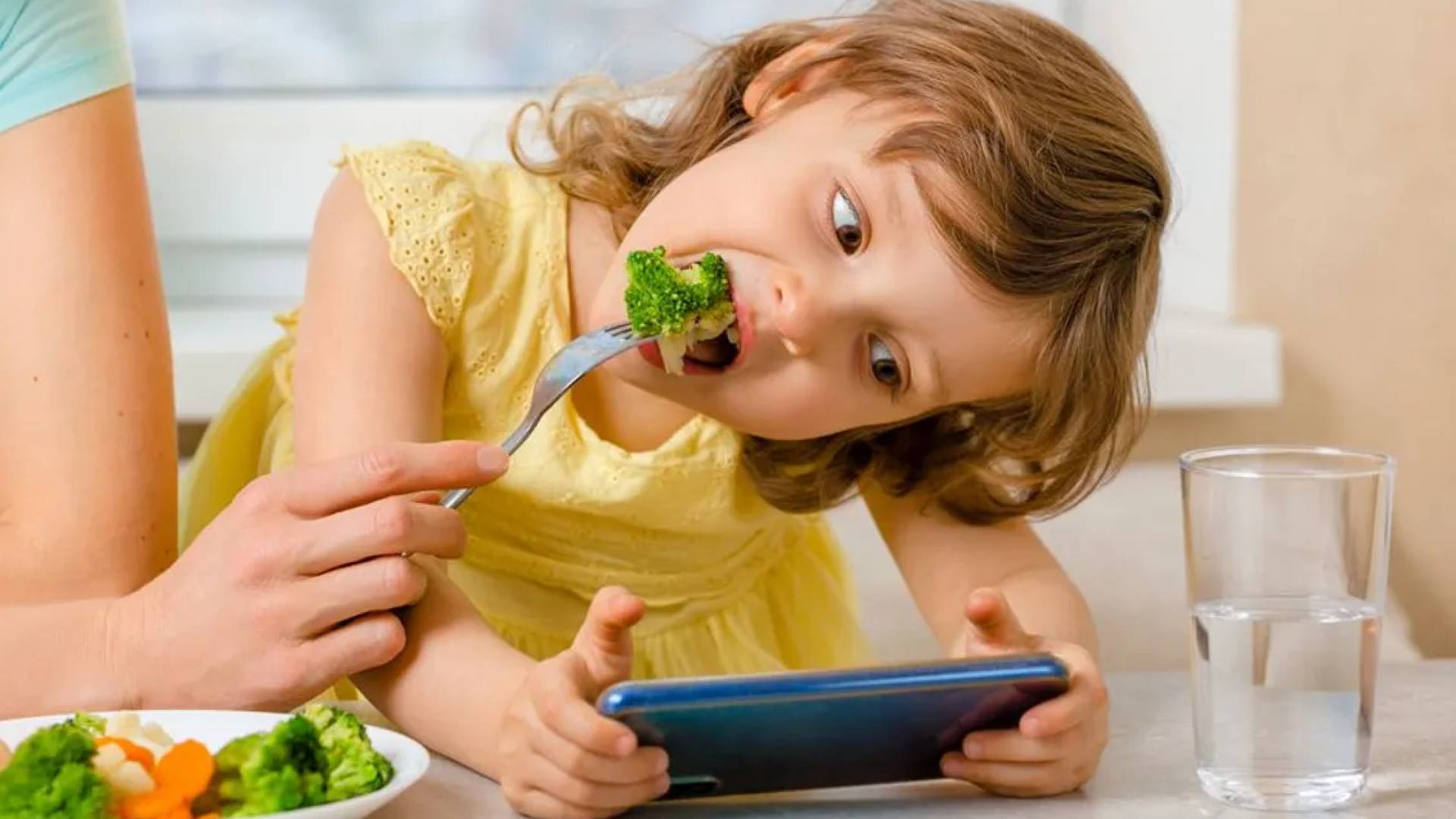 طفلة تأكل وتننظر للهاتف