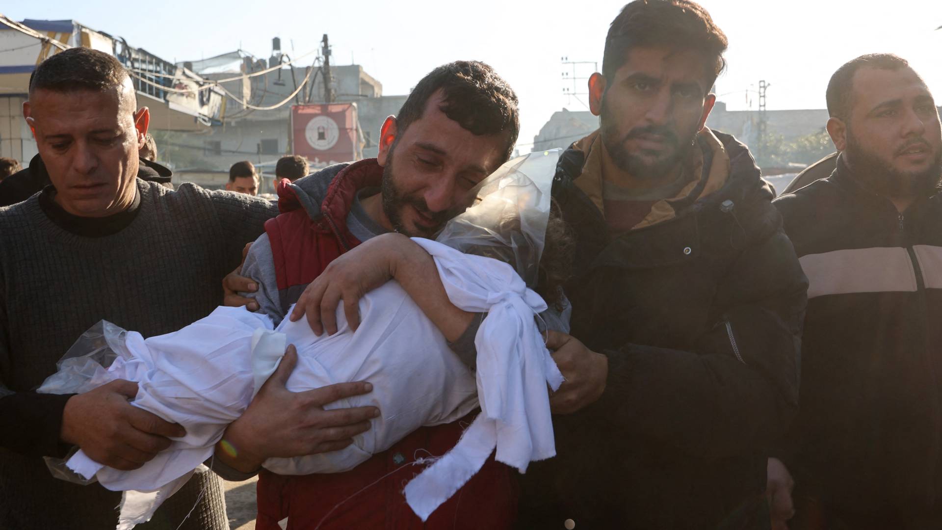 فلسطيني يحمل جثمان نجله الشهيد في غزة