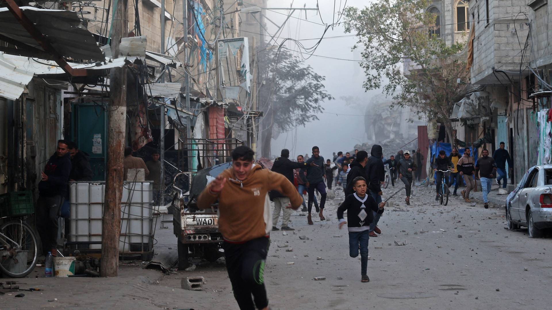 يركض الناس بحثا عن ملجأ بينما يتصاعد الدخان من مبنى دمرته غارة جوية للاحتلال على مخيم البريج وسط قطاع غزة