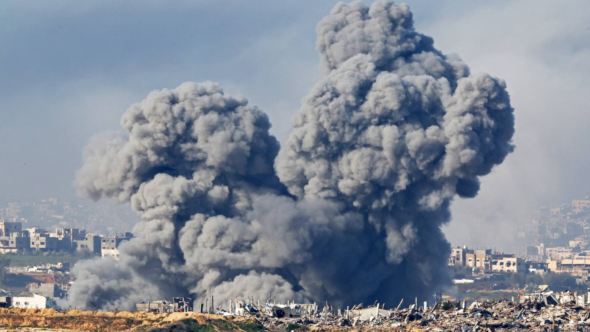 أعمدة الدخان تتصاعد من الانفجارات فوق المباني المدمرة في شمال قطاع غزة