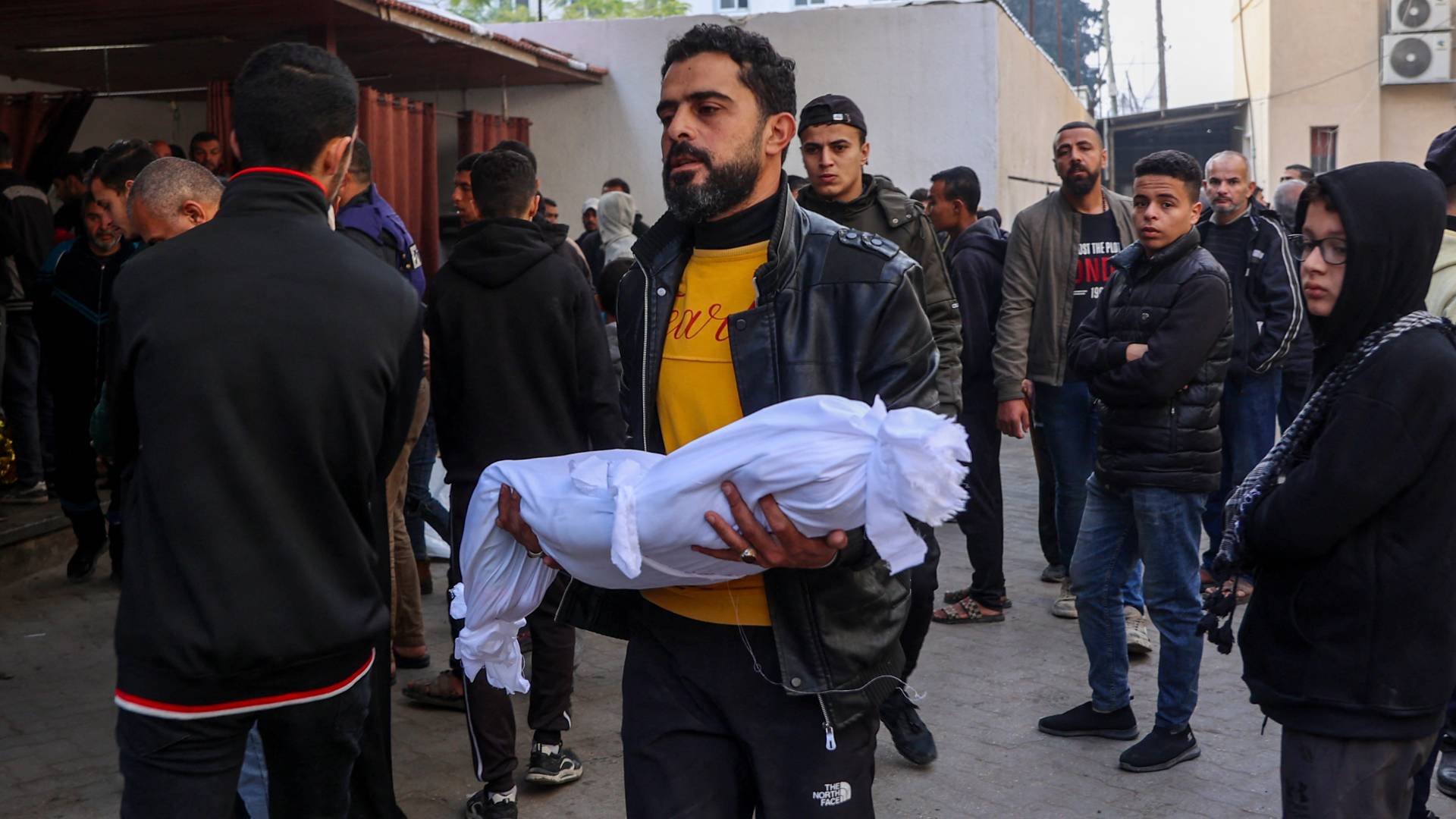 فلسطيني يحمل طفله الشهيد في غزة