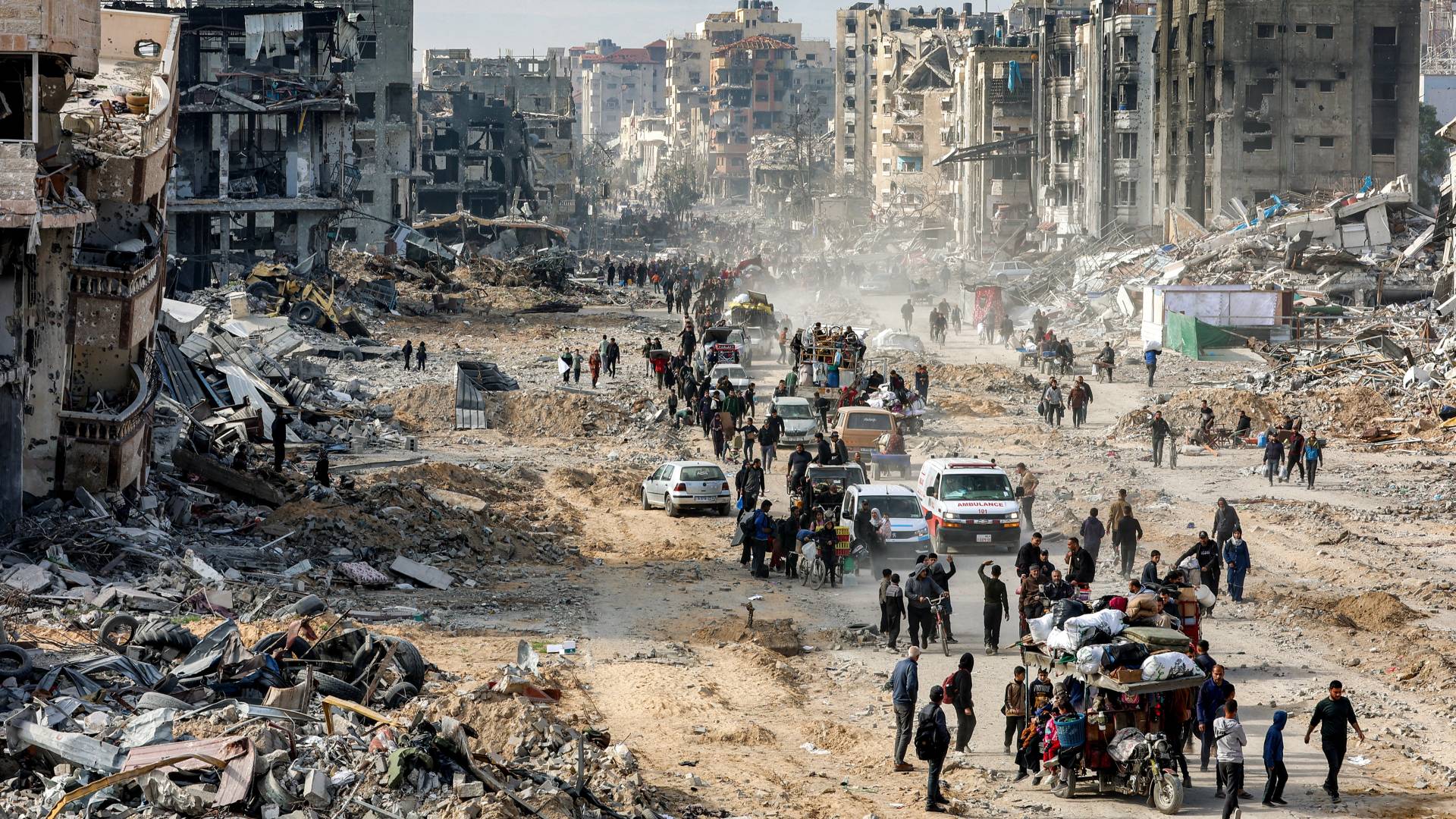 فلسطينيون بجانب أنقاض المباني المدمرة في جباليا شمال قطاع غزة