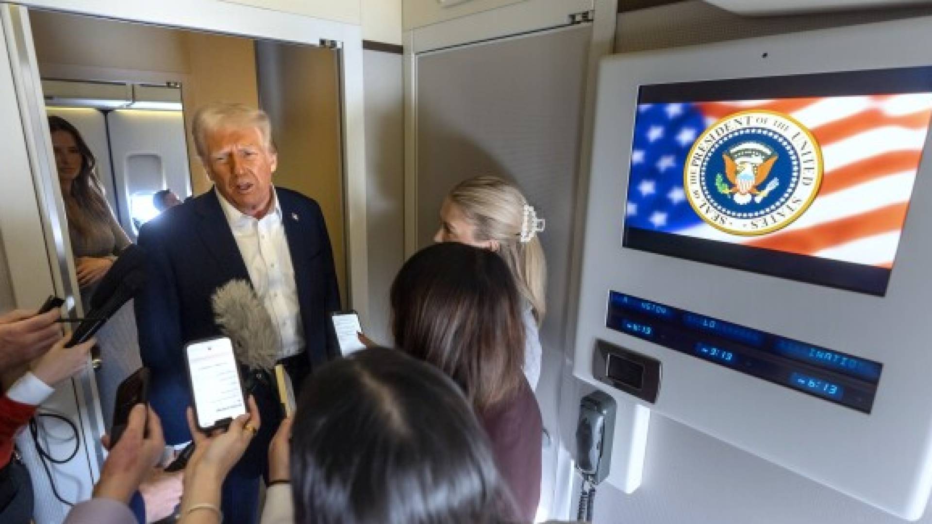 الرئيس الأمريكي دونالد ترمب يتحدث مع الصحافة، إلى جانب المتحدثة باسم البيت الأبيض كارولين ليفات (يمين)، على متن الطائرة الرئاسية.
