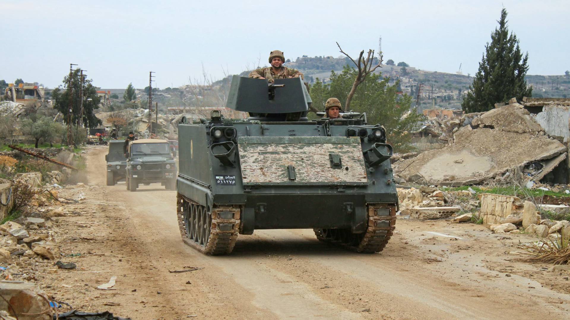 مركبات الجيش اللبناني تمر بجانب مبان مدمرة في قرية يارين بجنوب لبنان