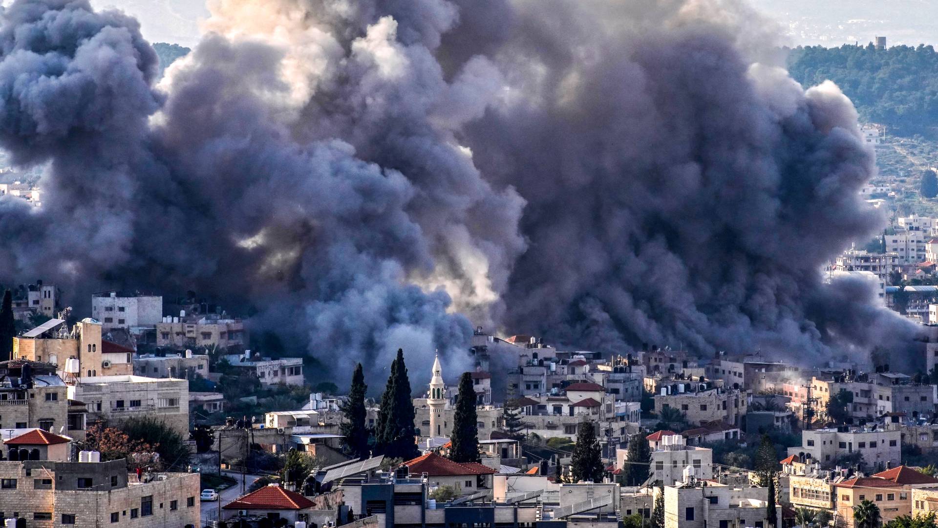 تصاعد الدخان من موقع عدة انفجارات خلال العدوان على مخيم جنين