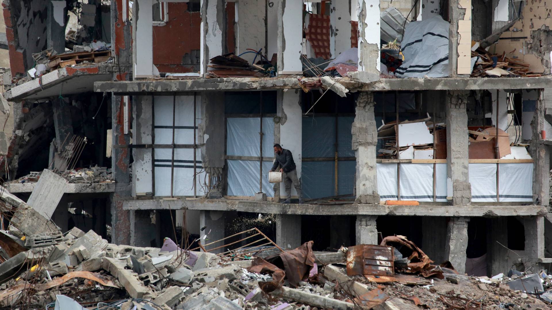 رجل فلسطيني يزيل الأنقاض في الطابق الأول من مبنى مدمر في جباليا في شمال قطاع غزة