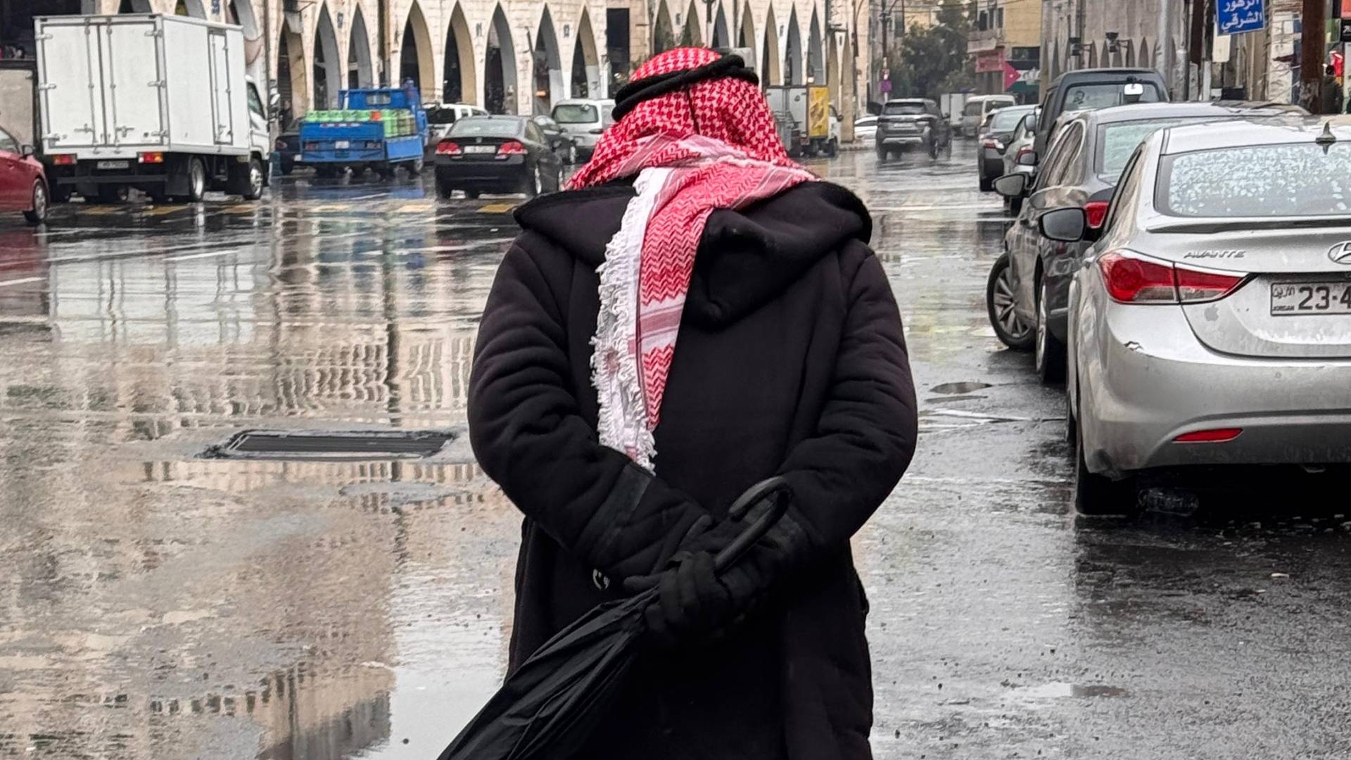 شخص يمشي تحت الأمنطار "أرشيفية رؤيا"