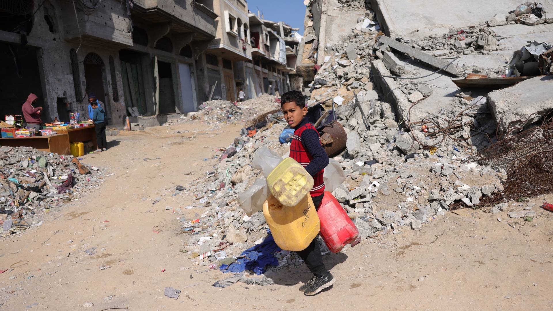 طفل من قطاع غزة يحمل عبوات مياه