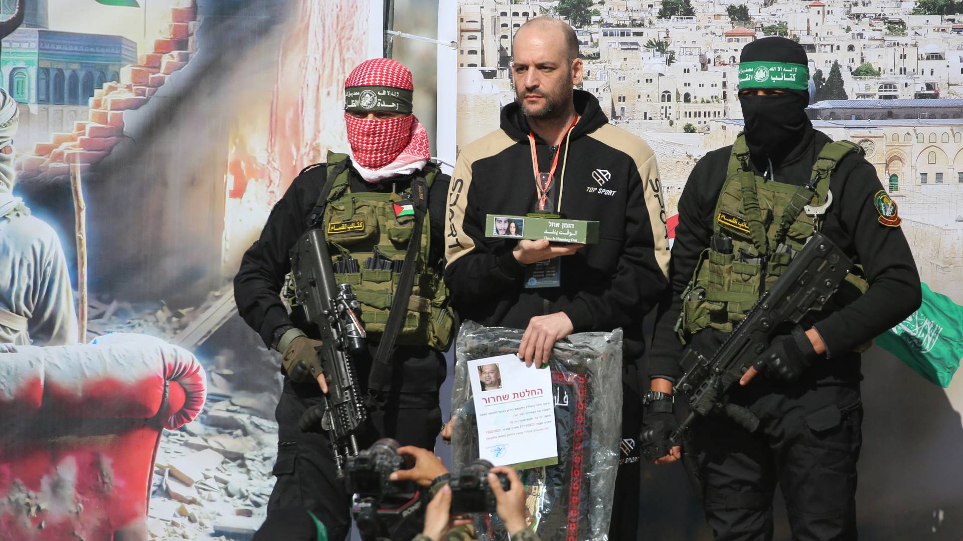 عناصر من المقاومة الفلسطينية خلال تسليم أحد محتجزي الاحتلال