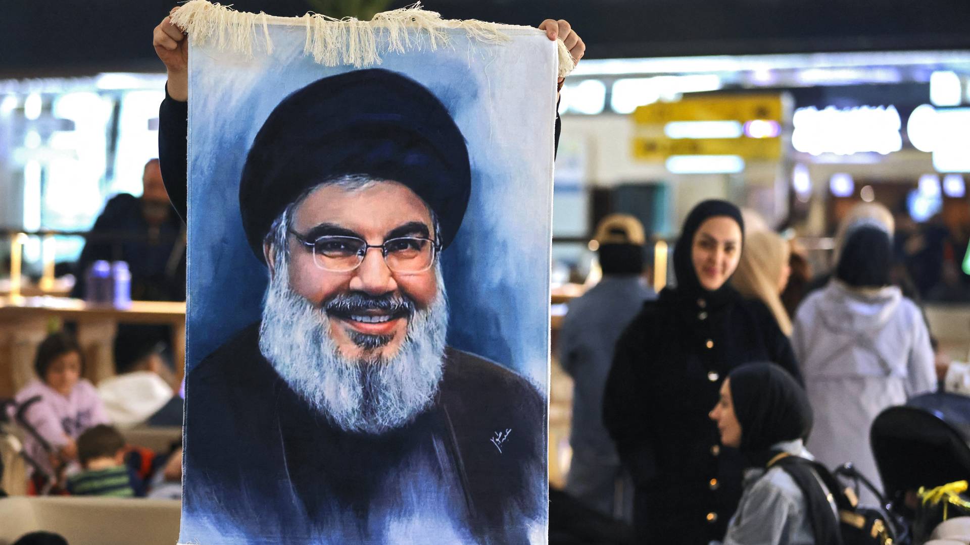 لبناني يرفع صورة الأمين العام لحزب الله حسن نصرالله