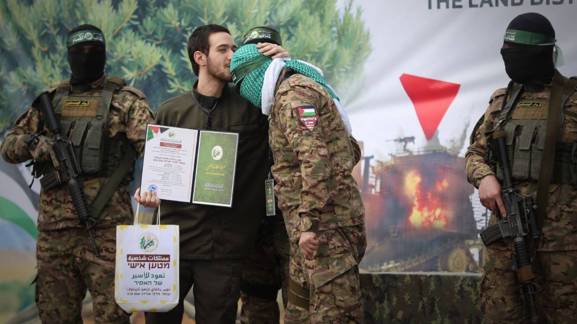 أحد المحتجزين يقبل رأس عنصر من كتائب القسام