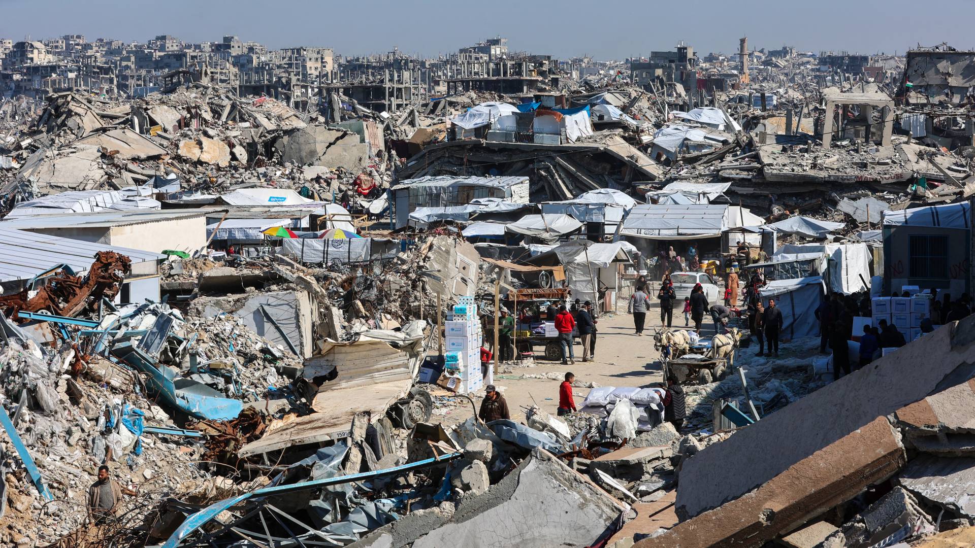 فلسطينيون بالقرب من أنقاض المباني المدمرة في جباليا شمال قطاع غزة
