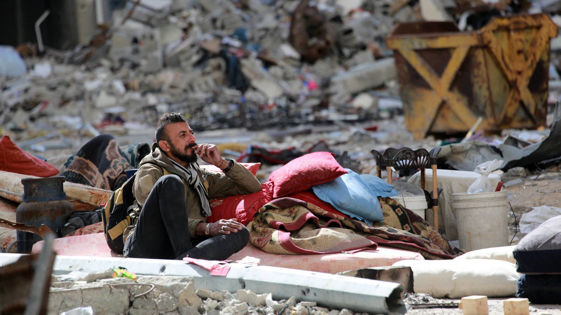 شخص يجلس بين الأنقاض في قطاع غزة