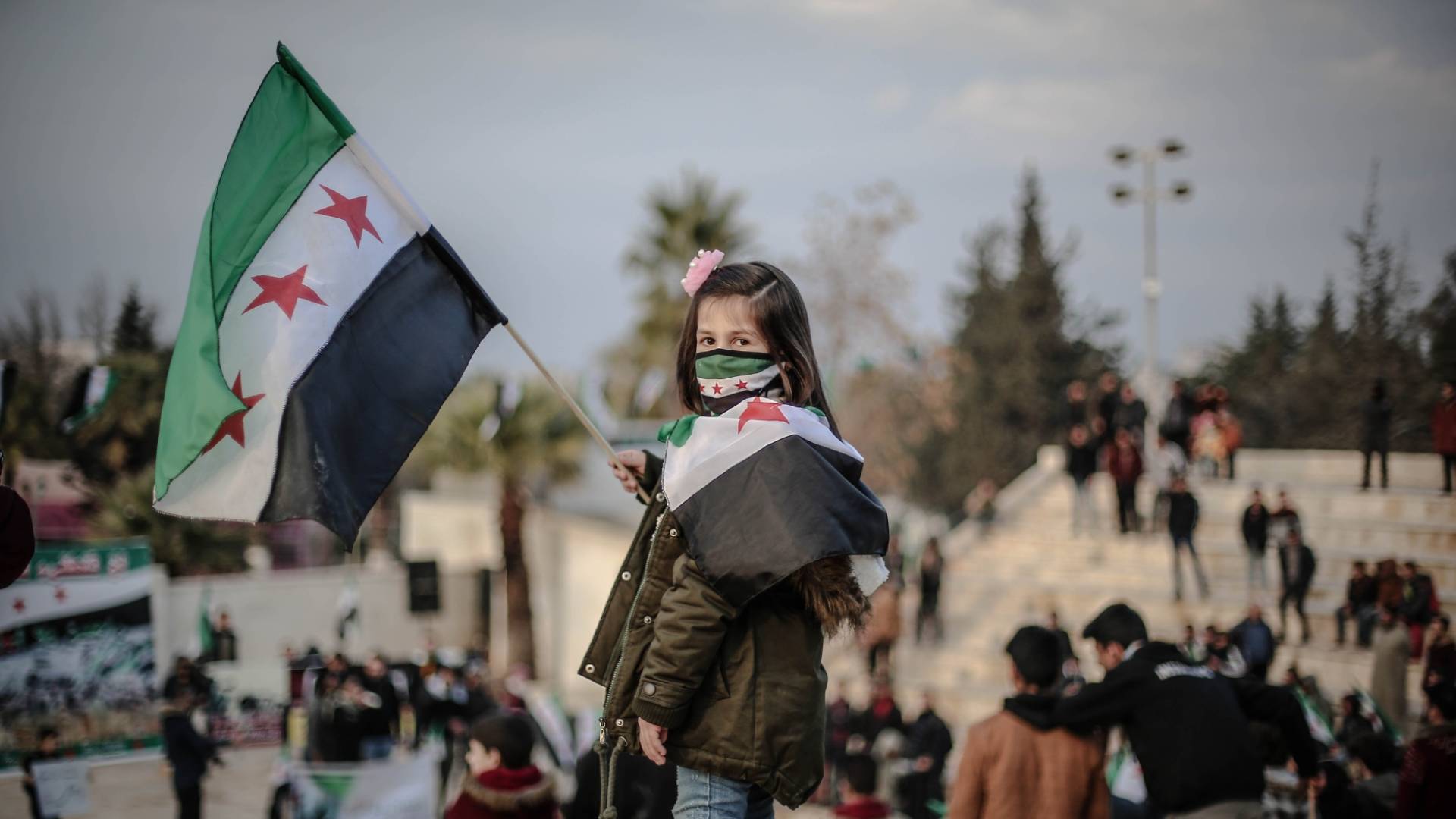 طفلة سورية ترفع علم سوريا الجديد