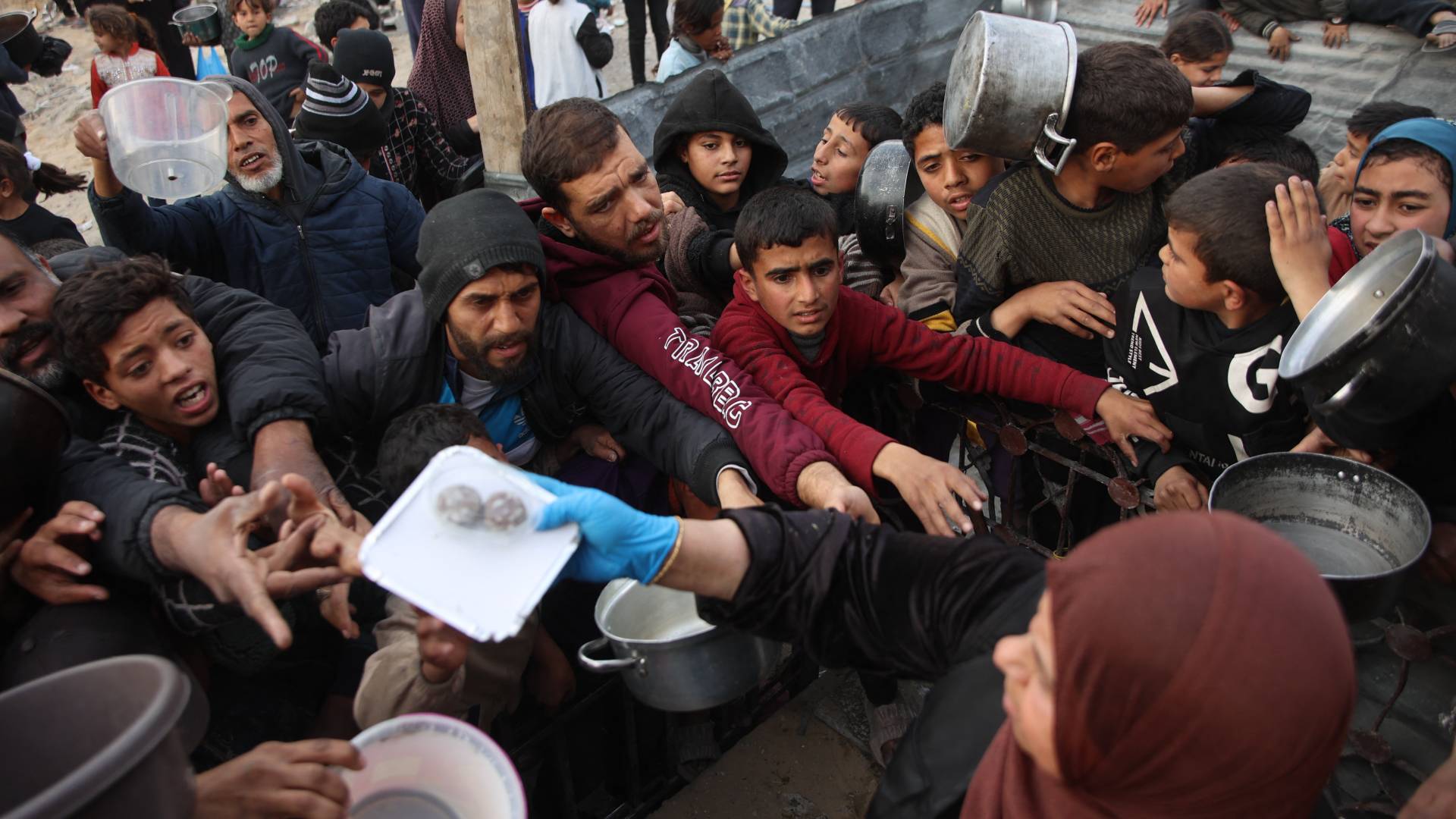 أشخاص يحاولون الحصول على الطعام في قطاع غزة