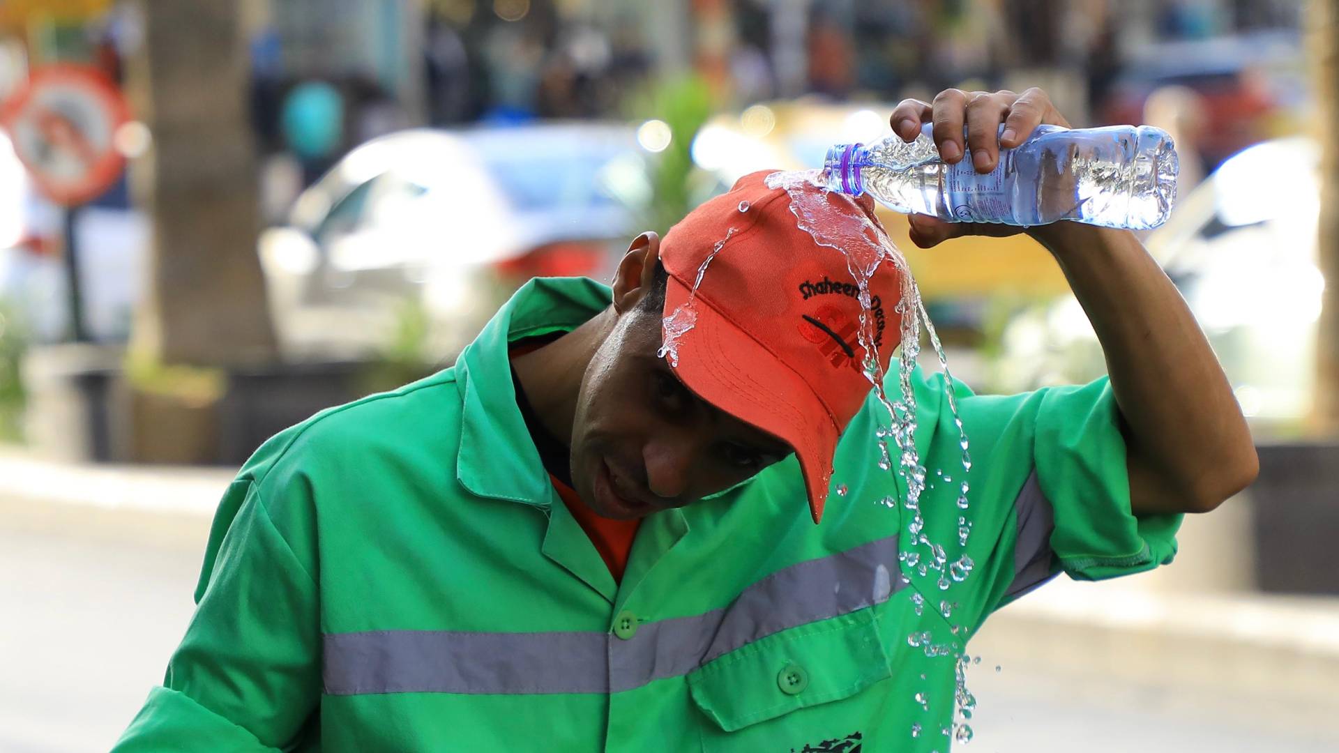 شخص يقوم بسكب الماء على نفسه خلال يوم حار