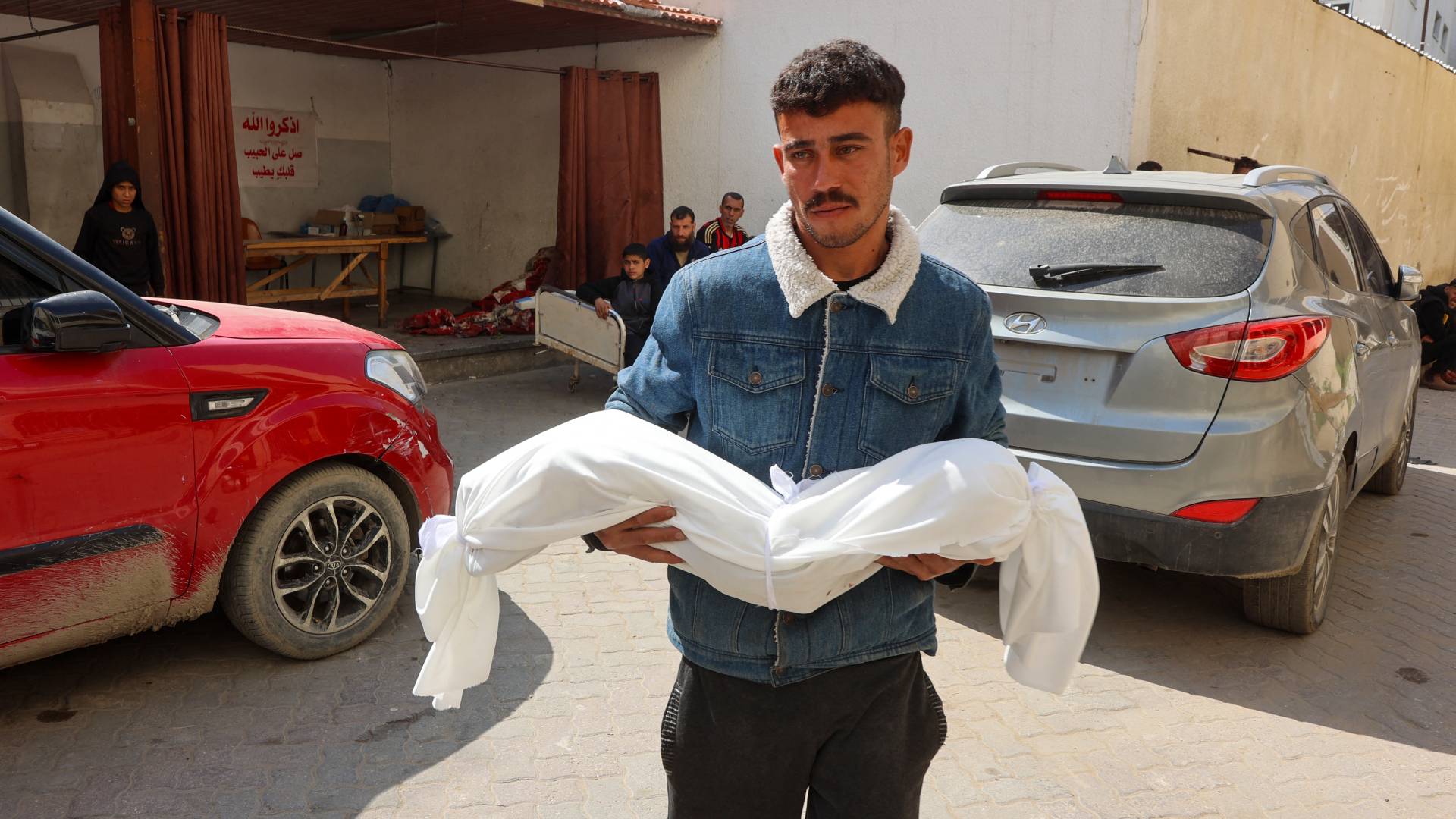 فلسطيني يحمل طفله الشهيد في غزة