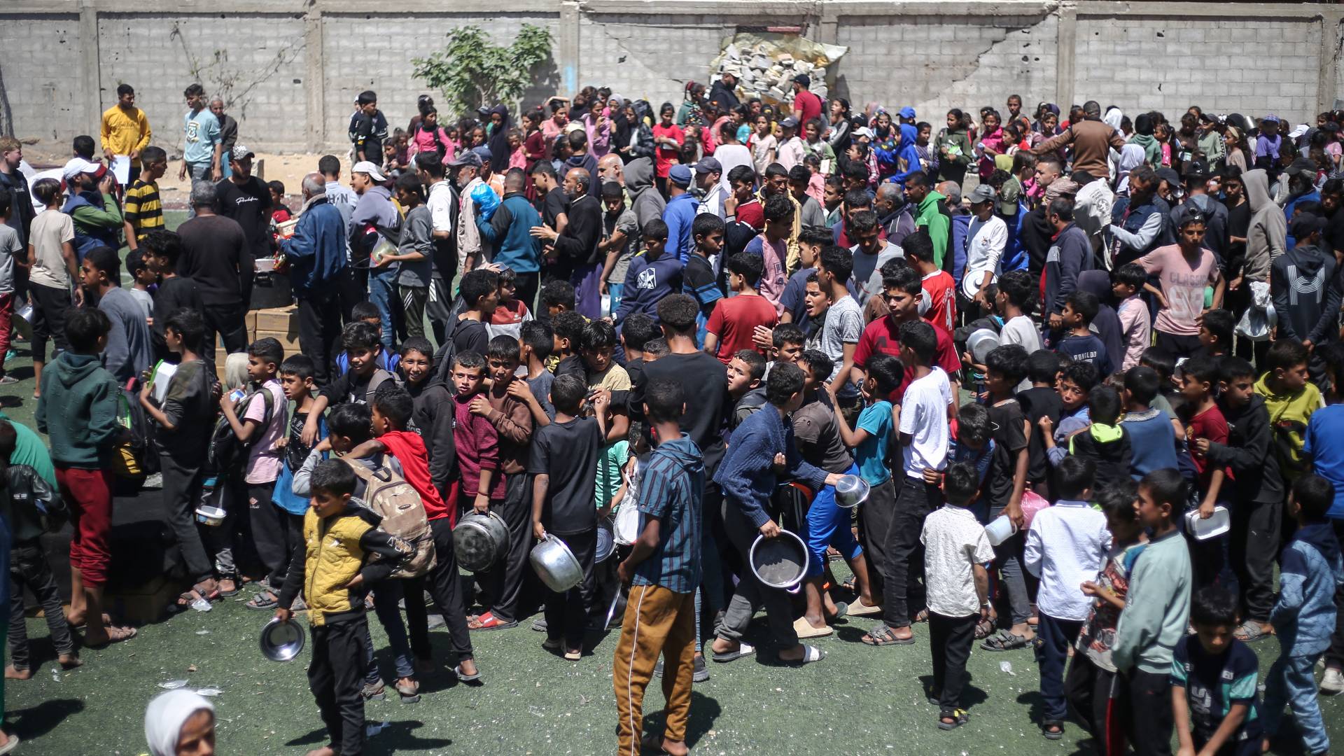 فلسطينيون في غزة يبحثون ينتظرون دورهم بالحصول على الطعام