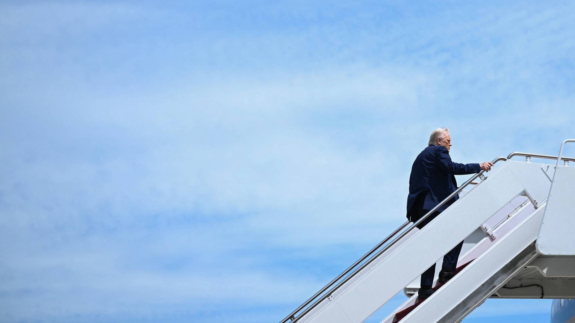 الرئيس الأمريكي دونالد ترمب خلال صعوده سلم الطائرة