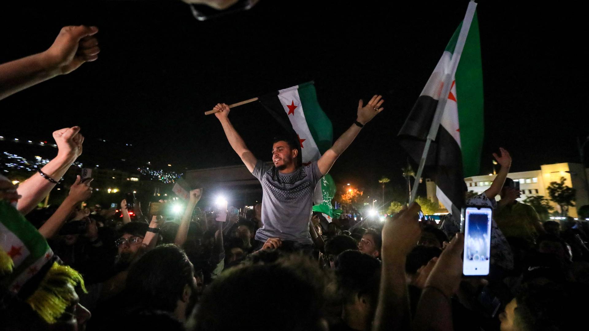 يحتفل الناس في ساحة الأمويين بدمشق بعد إعلان الرئيس الأمريكي رفع العقوبات عن سوريا