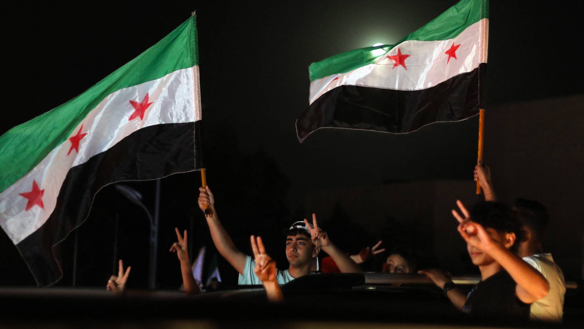 رجال يرفعون العلم السوري