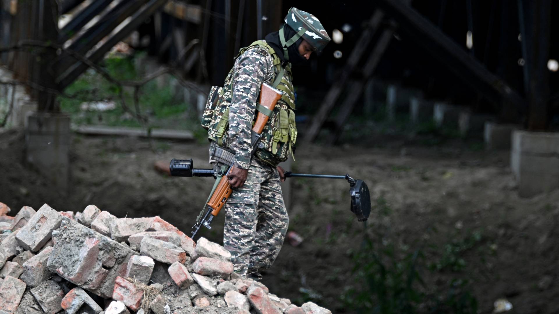 جندي هندي يحمل جهاز كشف المتفجرات أثناء دوريته قرب ضفاف نهر جيلوم في سريناغار