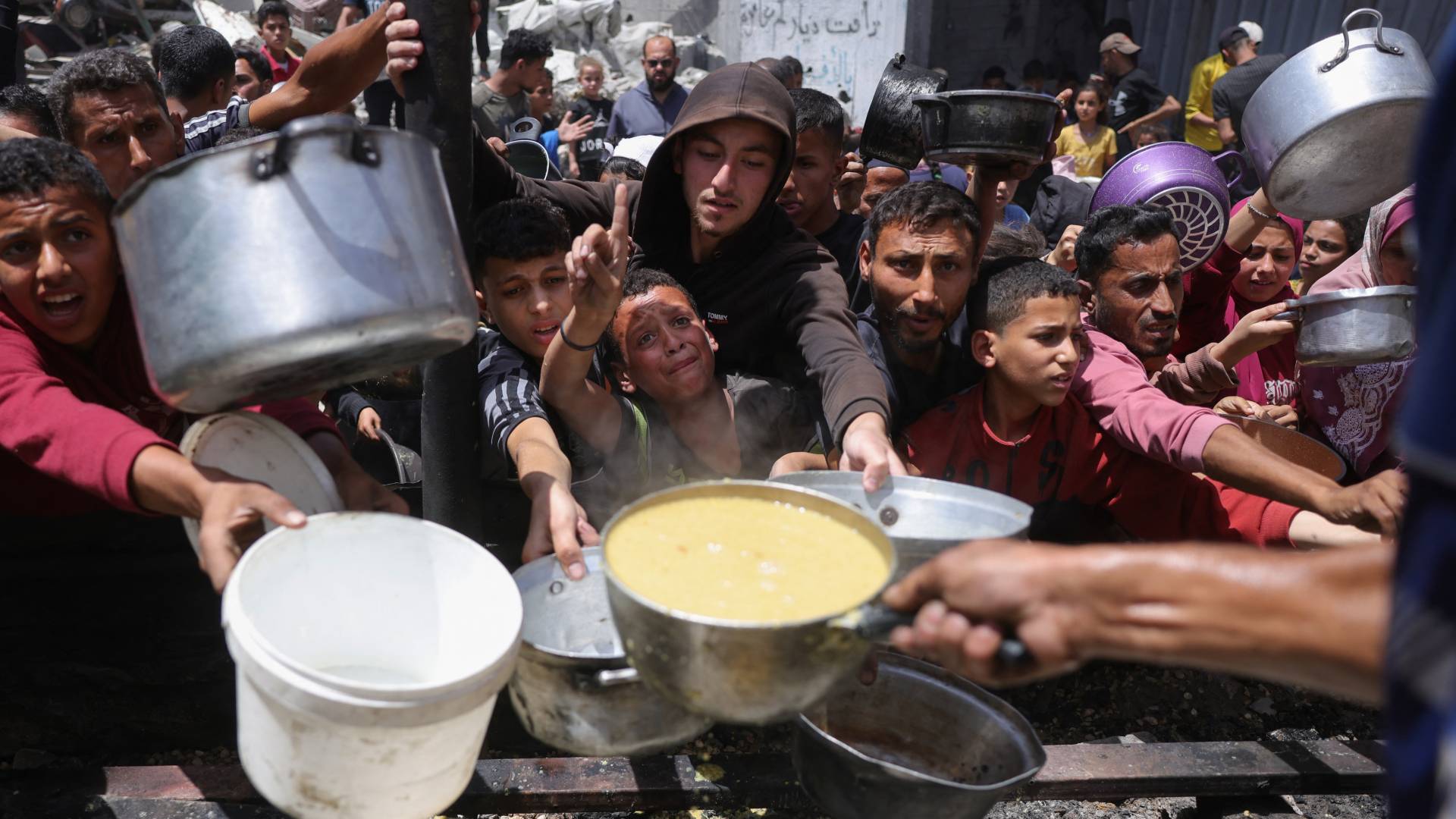 فلسطينيون في غزة ينتظرون دورهم للحصول على القليل من الطعام