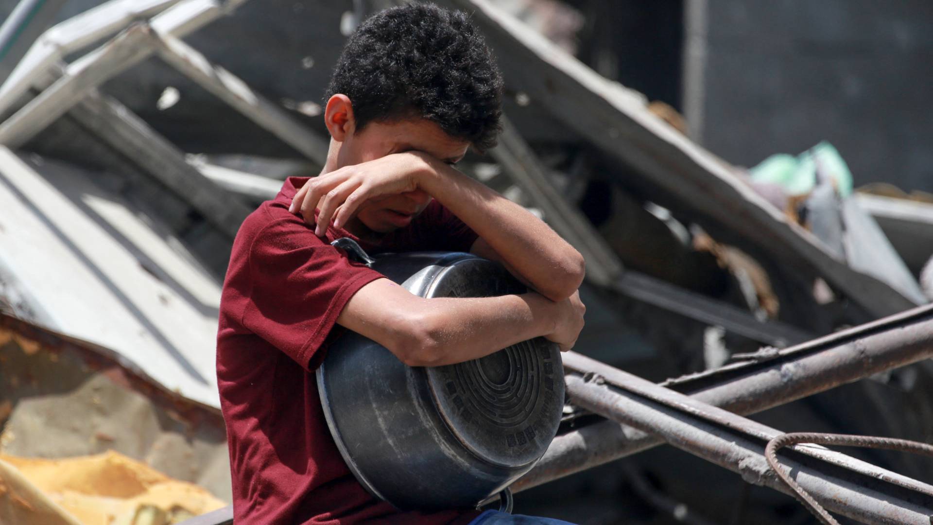 طفل فلسطيني في غزة يحمل وعاء وينتظر دوره للحصول على الطعام