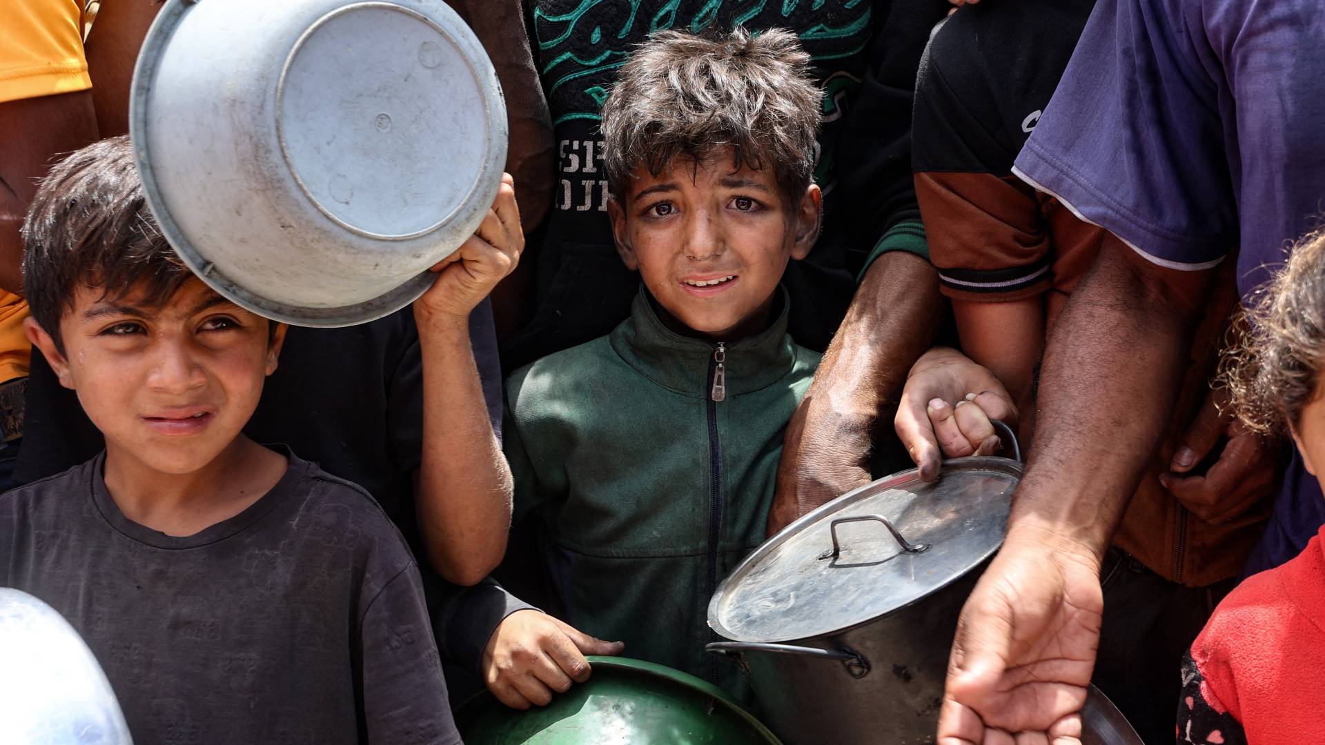 أطفال فلسطينيون ينتظرون دورهم للحصول على القليل من الطعام في غزة